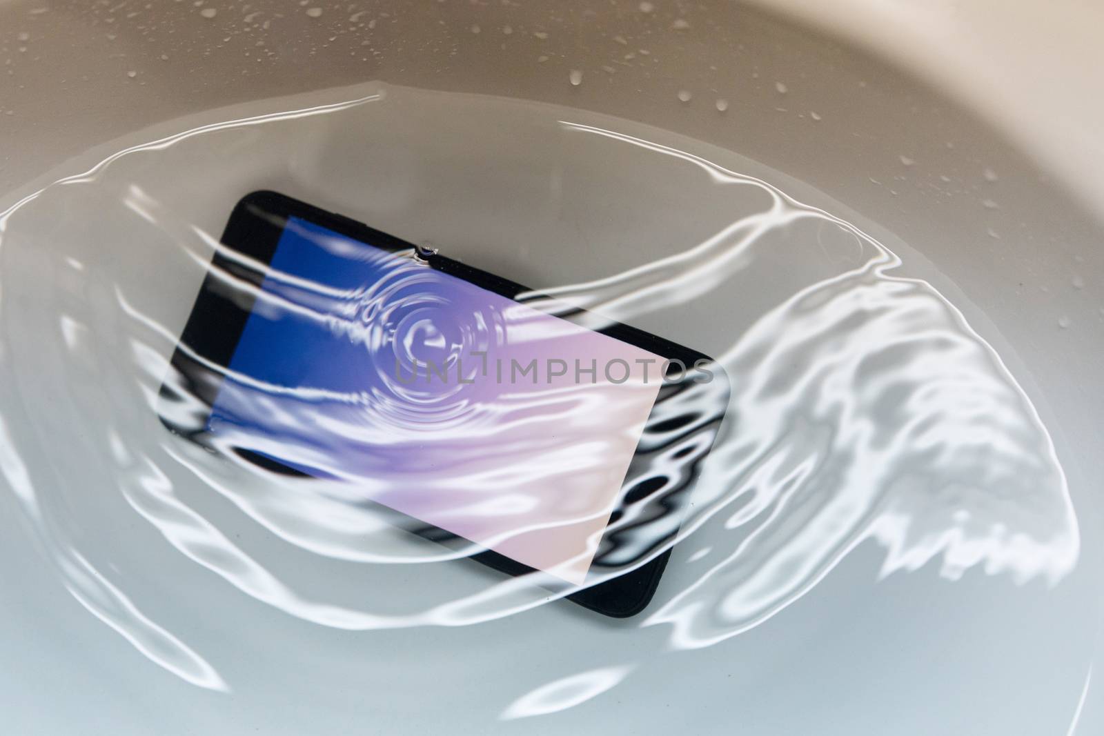 Close-up on Water Proof Smartphone Drop in to the Sink with Full of Water