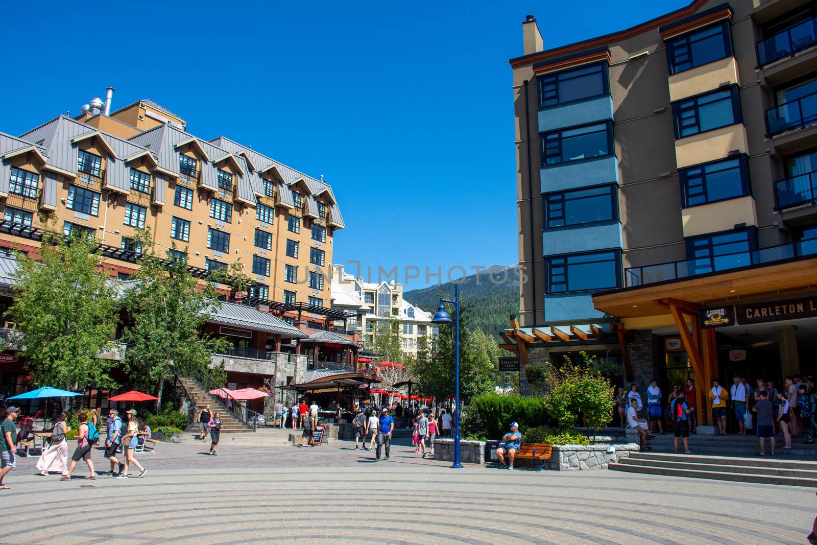 "Whistler, British Columbia/Canada - 08/07/2019: Carleton Lodge in Whistler village outside streets during the summer looking at the walkway, street, shops, hotels, and tourists enjoying this Olympic world class destination."