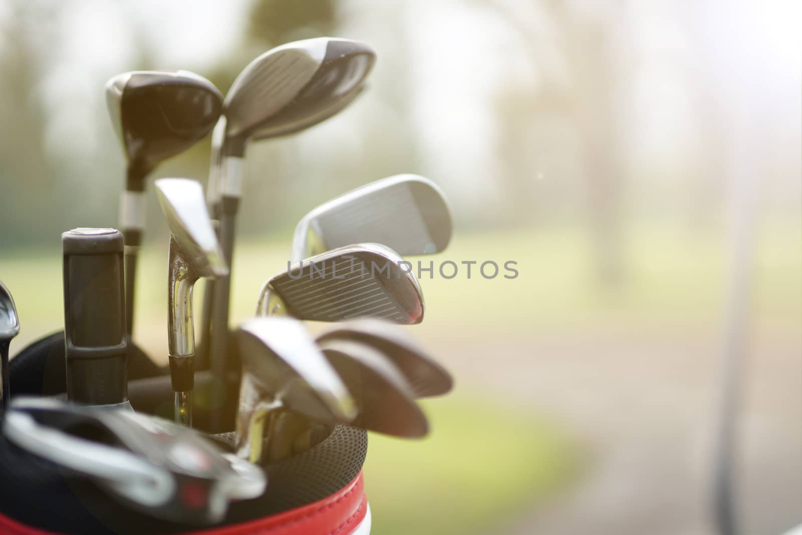 set of golf clubs in a golf bag with  fairway background by Charnsitr