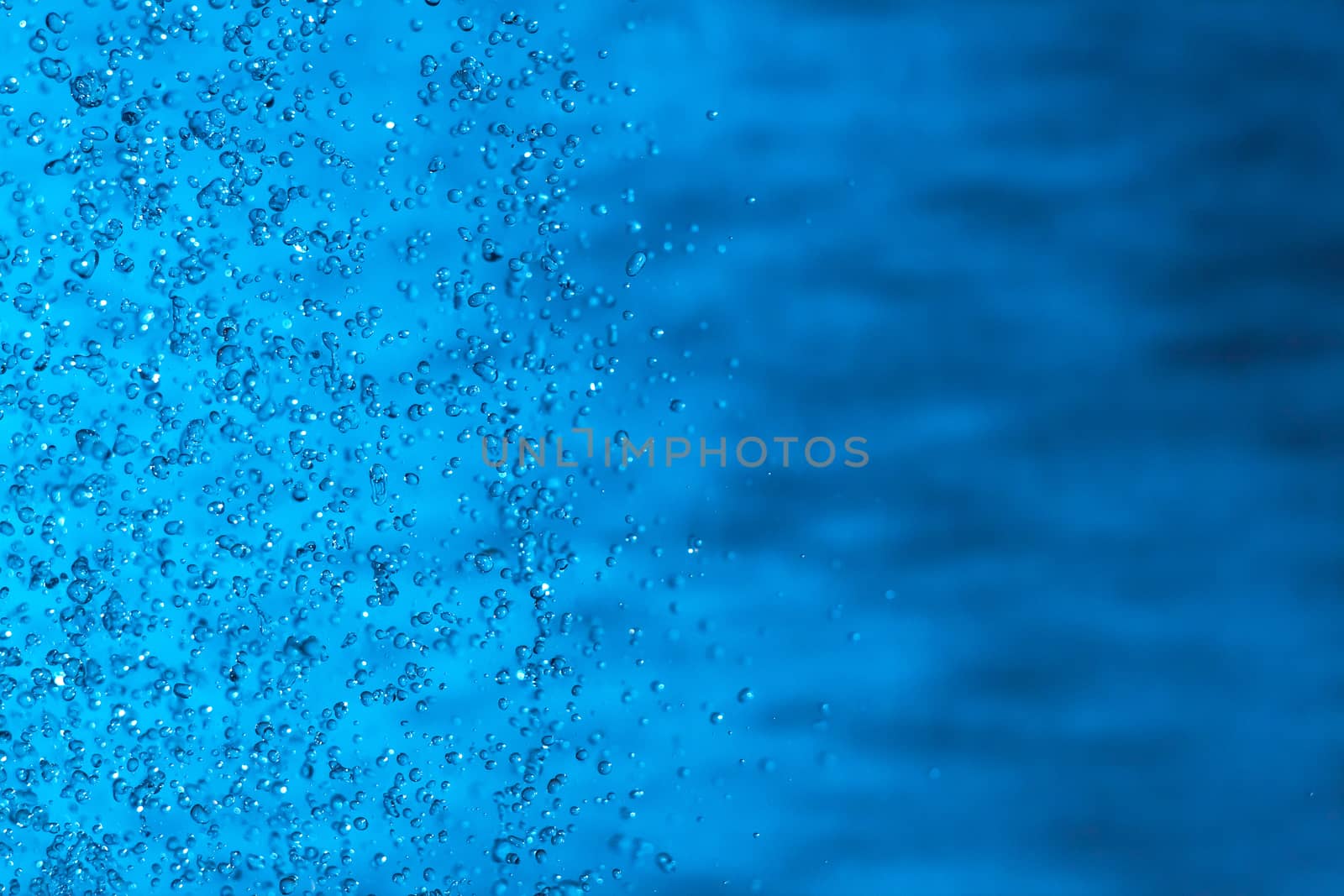 Water splashes on blue background. Spray. Drops of water on the glass window. Rain, shower. sprinkle a little, pour