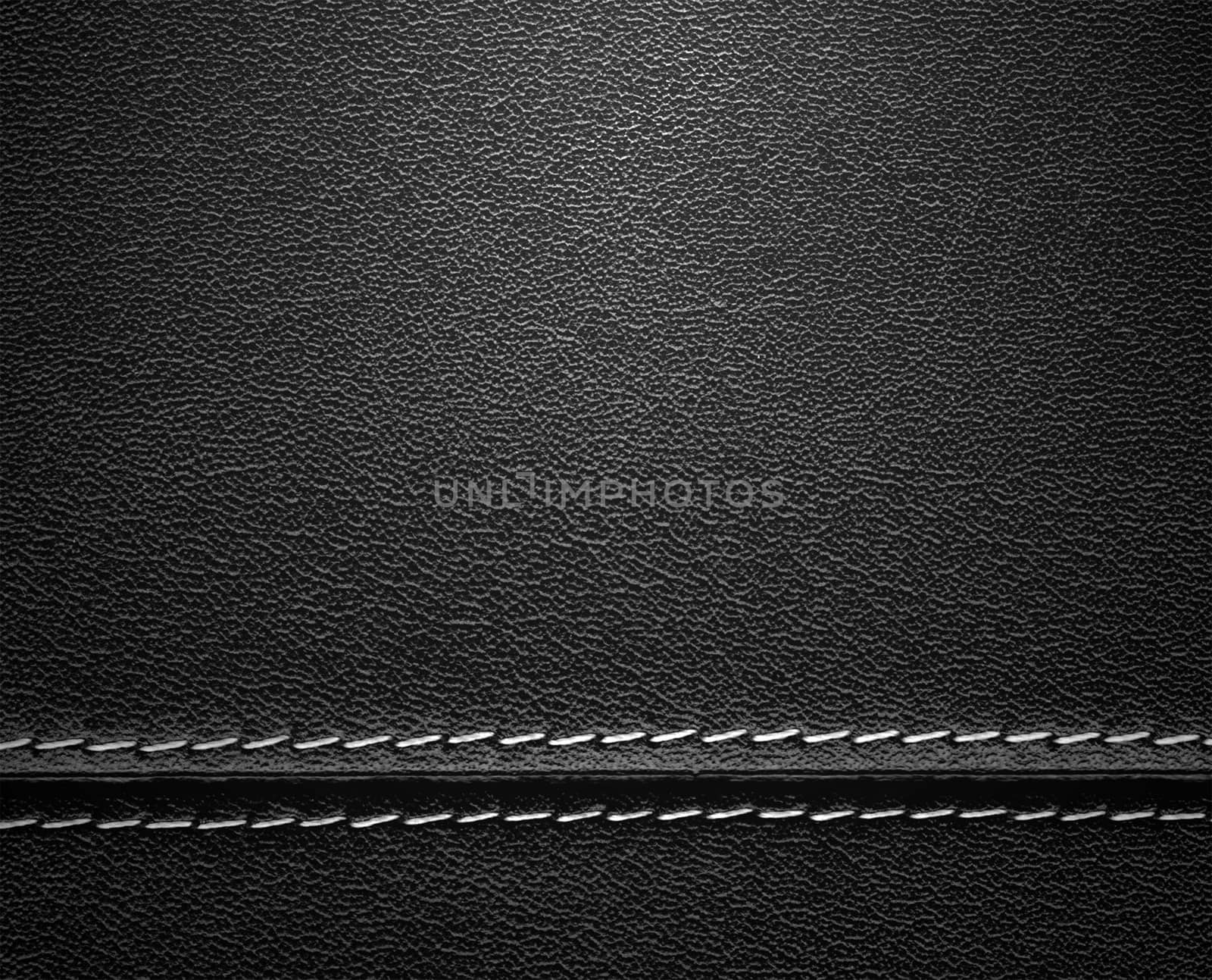 Real close-up of black leather background texture with horizontal stitch.