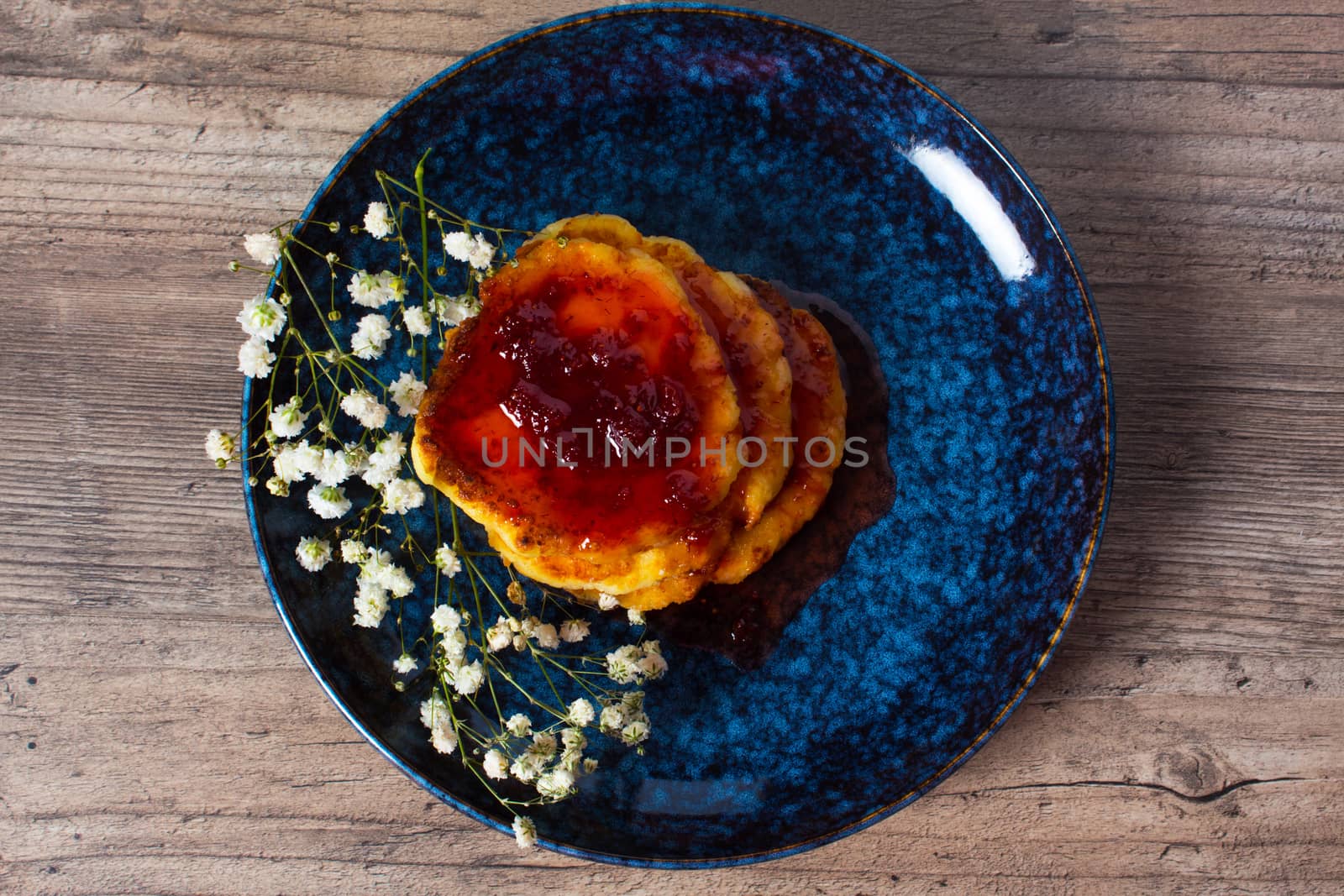 Breakfast, food. Pancakes with strawberry jam on a blue plate with flowers. Lunch, snack. Family meal. Home cooking. Flat lay.
