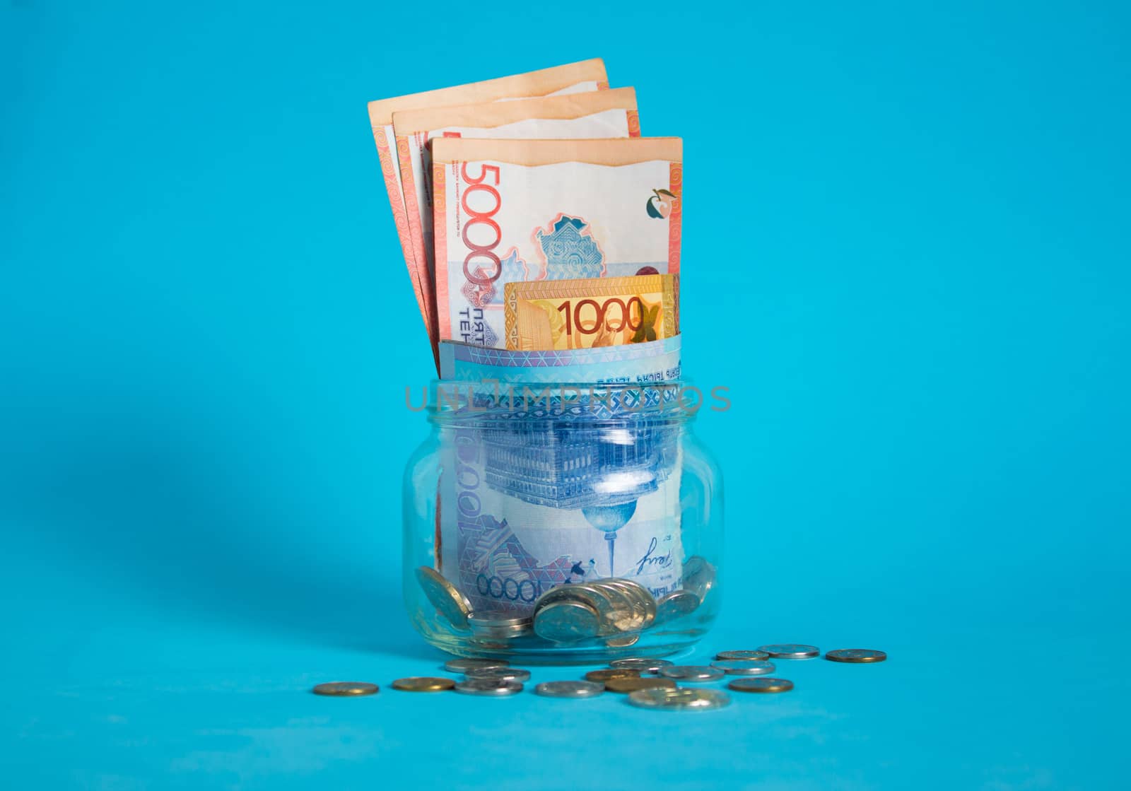 Tenge in a glass jar. Kazakhstan, KZ, KZT. Banknote, paper currency, coins, Bank. Salary, credit, savings, pay and spend. Business and Economics.