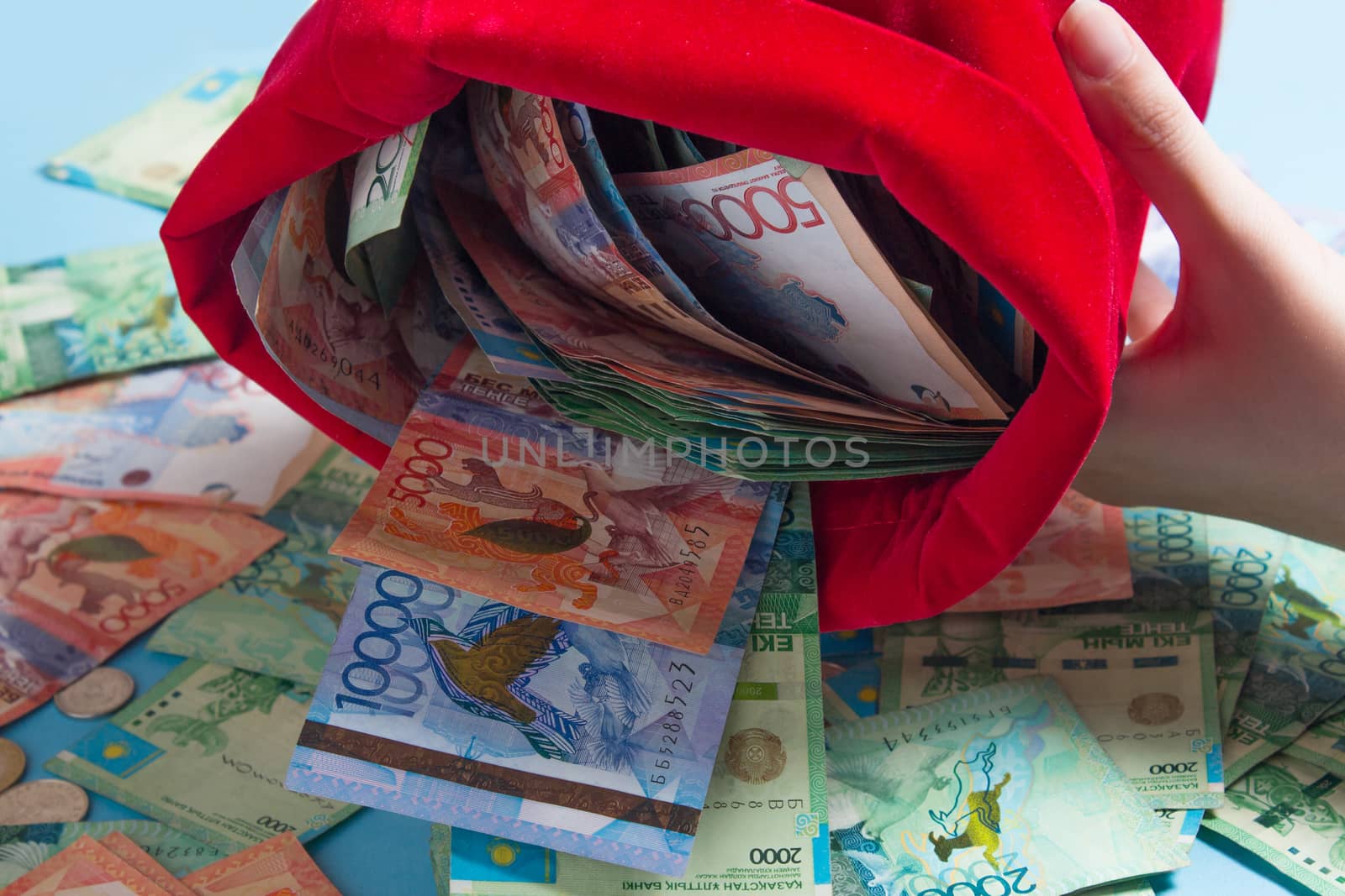 Pour the tenge out of the bag. Kazakhstan, KZ, KZT. A lot of money in a red bag. National currency, banknote. Bank, Finance, economy, inflation. Wealth, capital, investment.