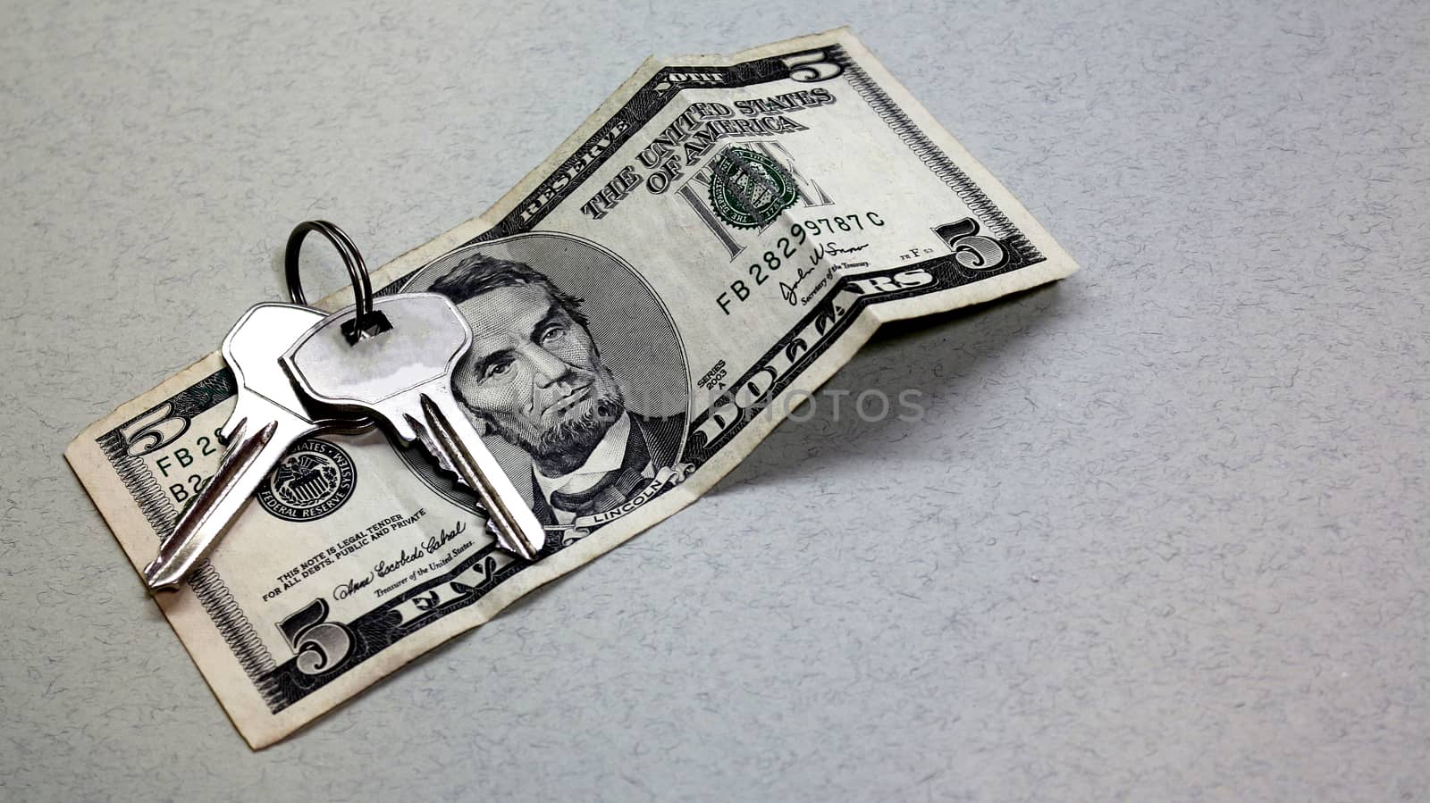 Real estate agencies and realtors buying property and sale of apartments, real estate, buildings , offices, houses. Buying an apartment or real estate for money, get the keys to housing. Wallet, keys .keys and dollars on grey background