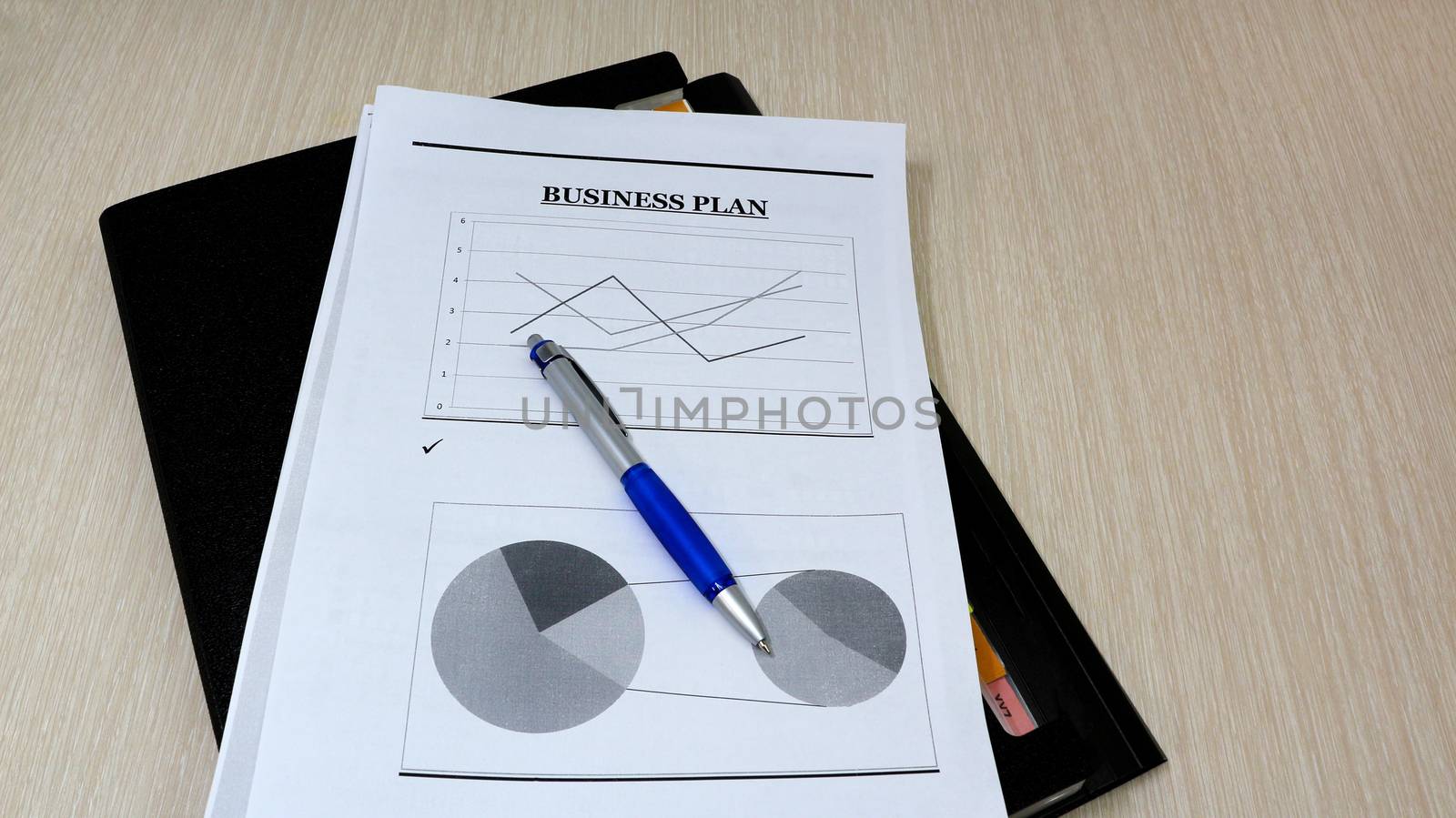 Job with finances in the office on a laptop,the employee holds paper with the inscription business plan.Businessman analyzes the chart of the rise or fall of prices and is a plan of action. starting a business	