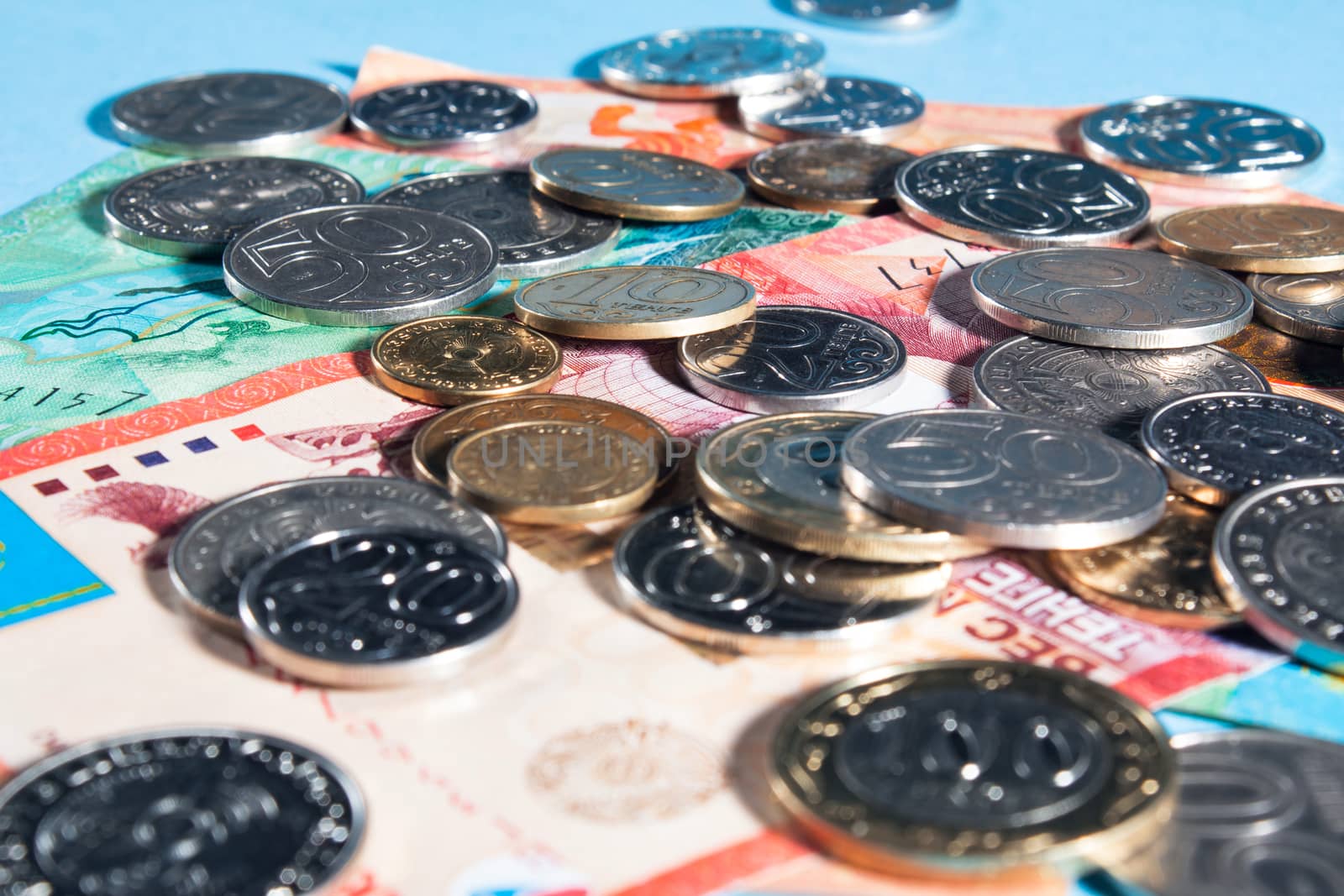 Tenge on a blue background with coins. Tenge banknotes. Coins Of by YevgeniySam