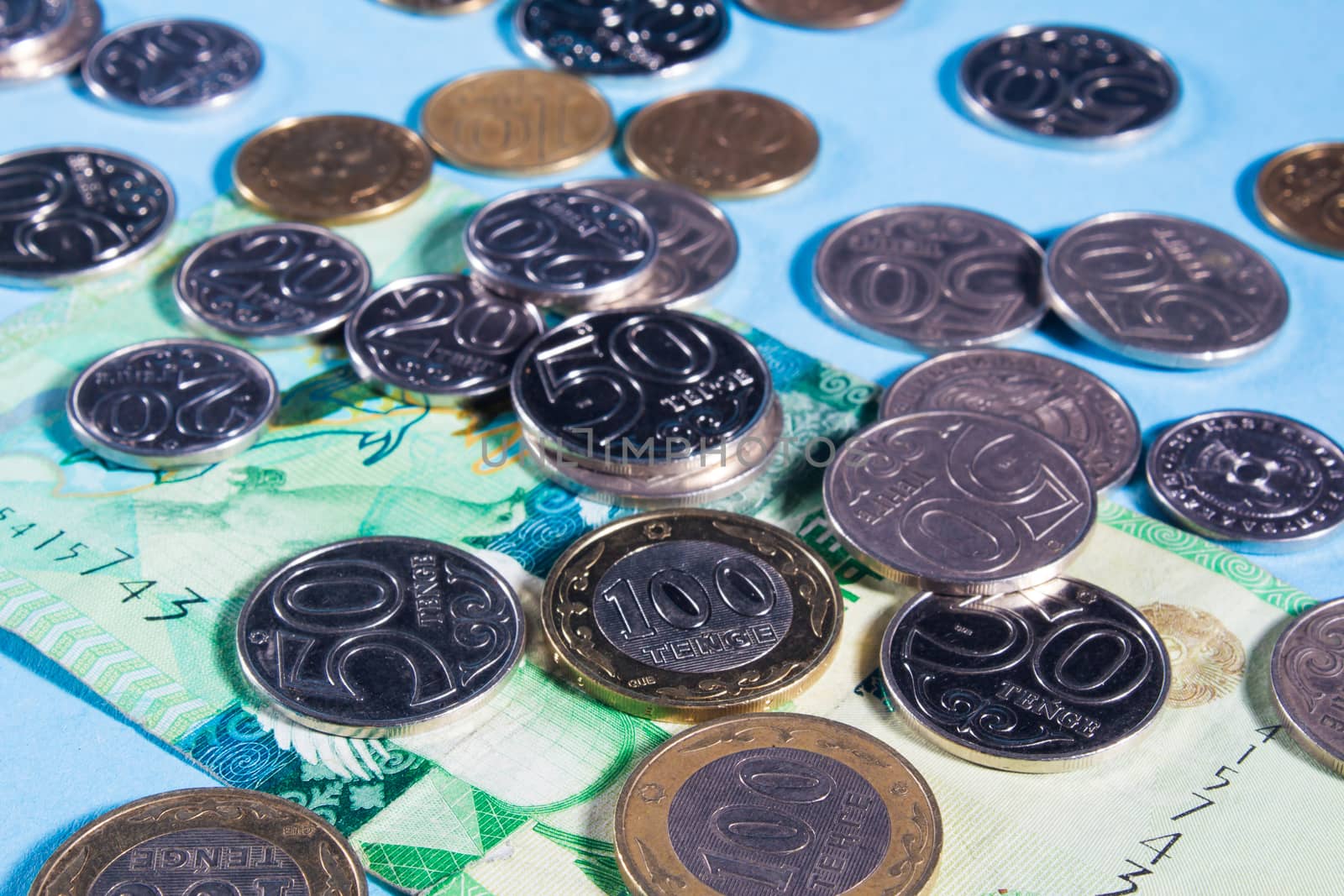 Tenge on a blue background with coins. Tenge banknotes. Coins Of by YevgeniySam