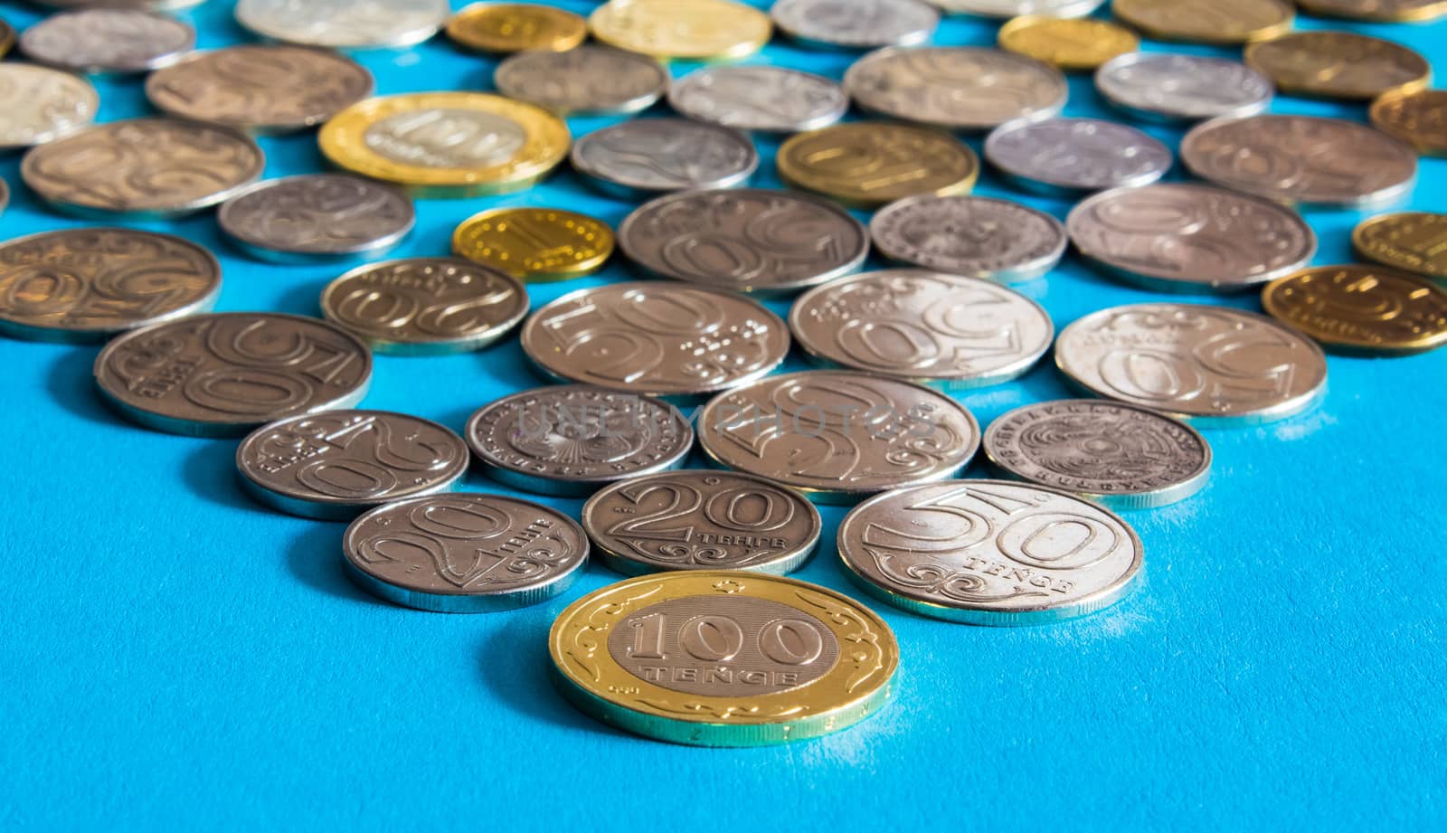 Tenge on a blue background with coins. Tenge coins of Kazakhstan