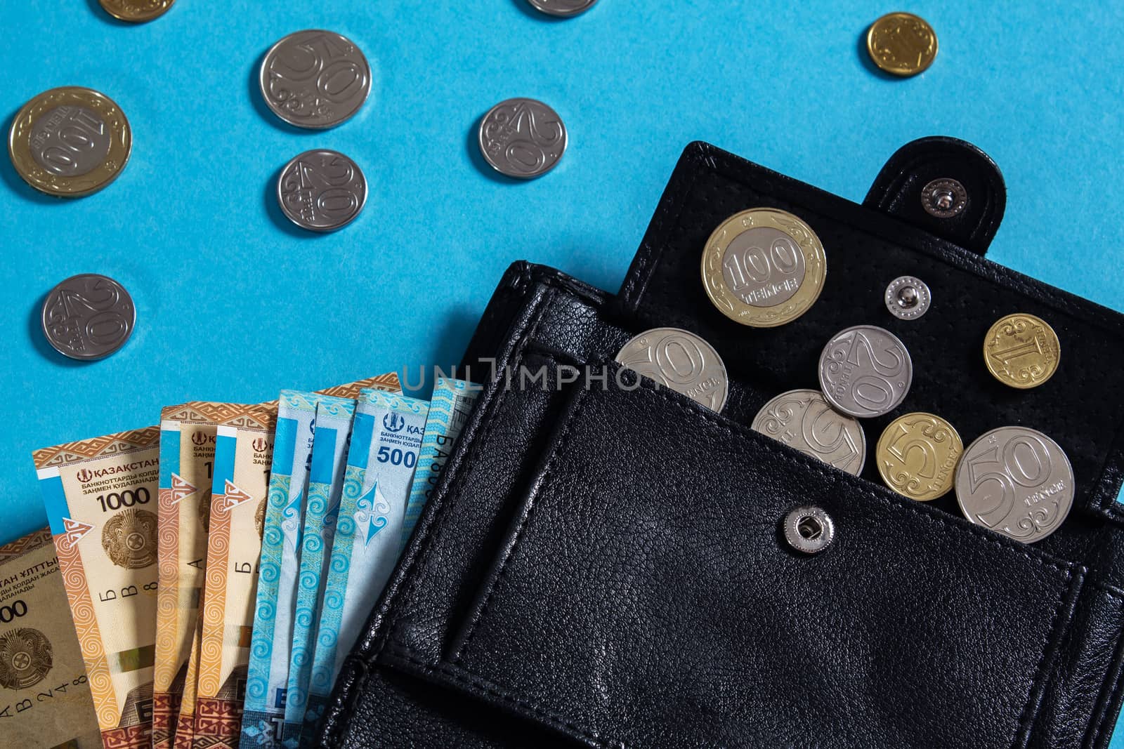 Tenge on blue background with coins. Tenge is the national curre by YevgeniySam