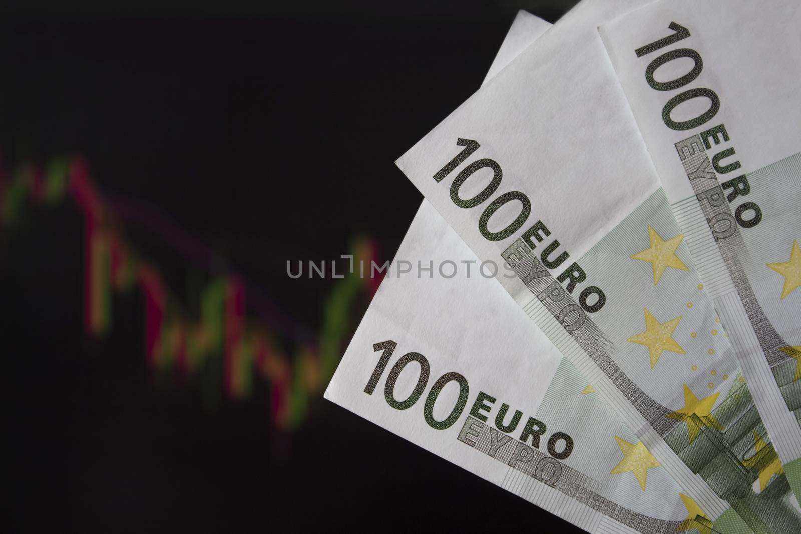 Hands holding euro, EUR in front of a laptop monitor with a price chart.Forex and trading.A trader trades stocks,bonds and securities or currencies on the Forex market or stock exchange for euro