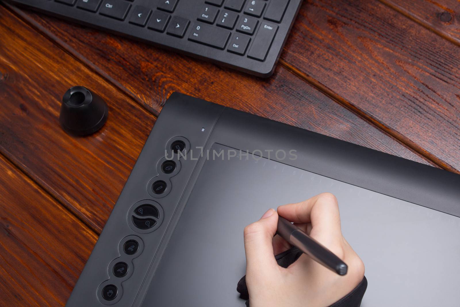 Graphic designer working on digital tablet. The hand draws on a graphics tablet. Freelance, designer, Illustrator. Technology, remote work, outsourcing. Glove and pen for a graphic tablet.  Project, c