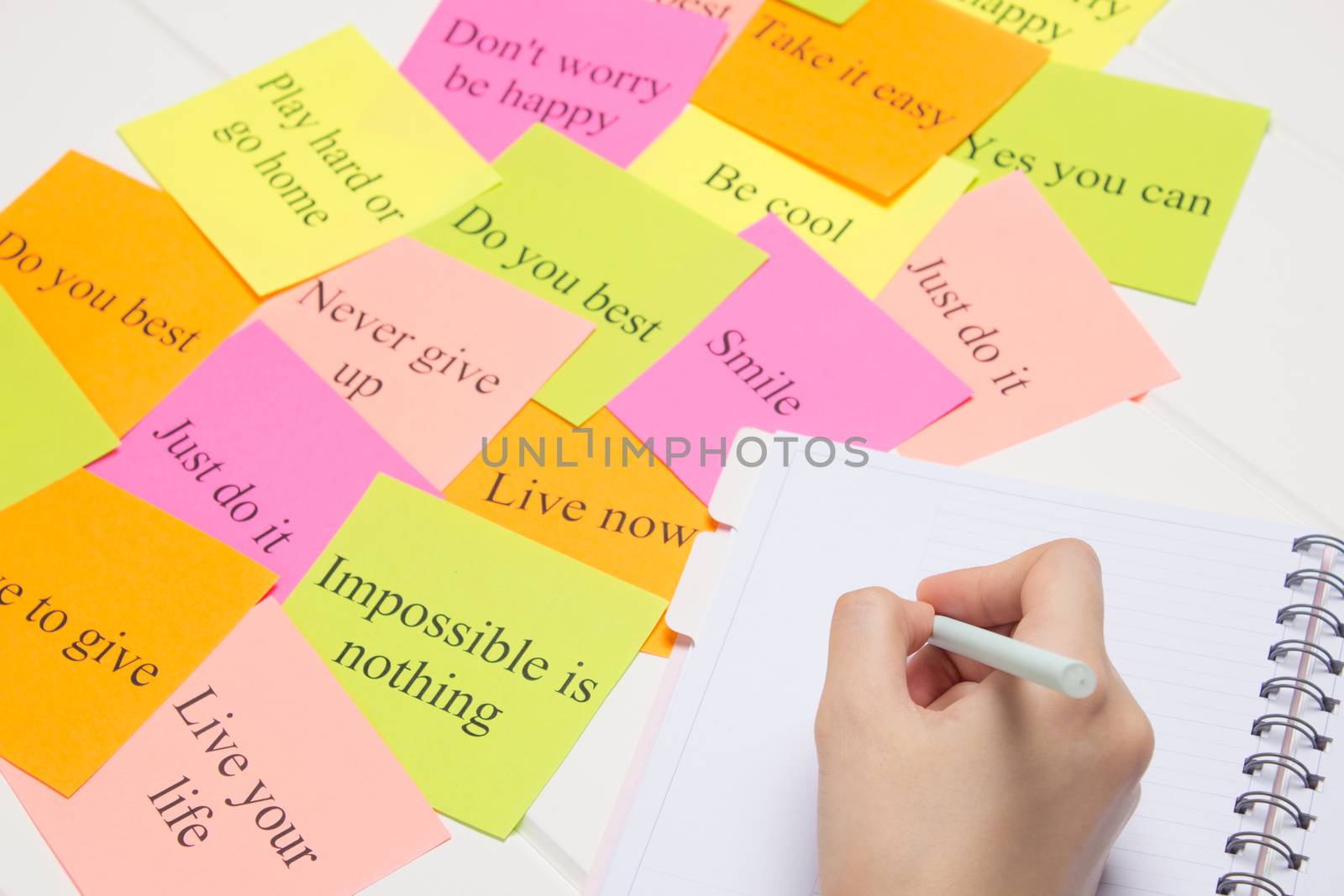 The hand writes on a white page in the daily planner.Student, study, synopsis. Affirmations, visualization, to-do lists. Plan, strategy, dream, desire. Cards with words. Concept, project.