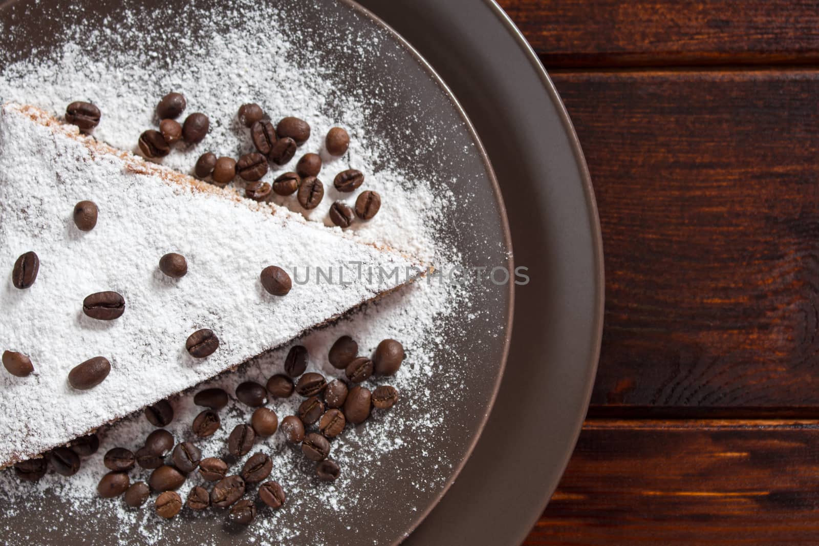A piece of chocolate cake with sugar and coffee beans. Food, dessert, sweet. Biscuit, brownie, tiramisu, cheesecake. Cook at home. Bakery products.