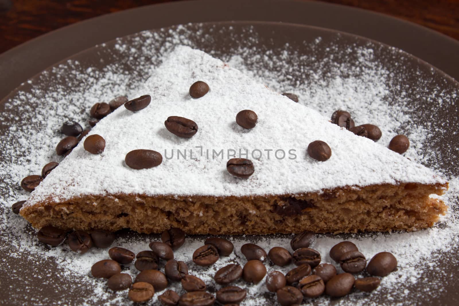 A piece of chocolate cake with sugar and coffee beans. Food, dessert, sweet. Biscuit, brownie, tiramisu, cheesecake. Cook at home. Bakery products.