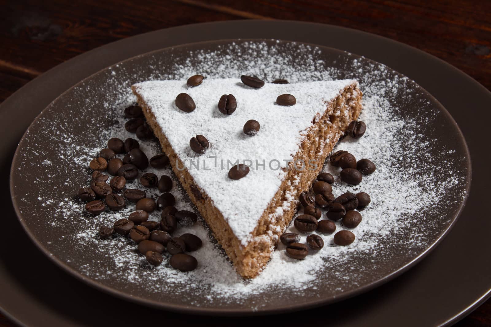 A piece of chocolate cake with sugar and coffee beans. Food, dessert, sweet. Biscuit, brownie, tiramisu, cheesecake. Cook at home. Bakery products.