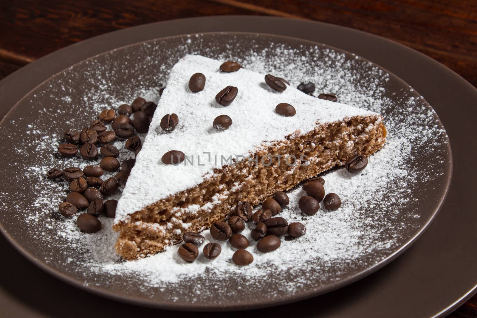 A piece of chocolate cake with sugar and coffee beans. Food, dessert, sweet. Biscuit, brownie, tiramisu, cheesecake. Cook at home. Bakery products.