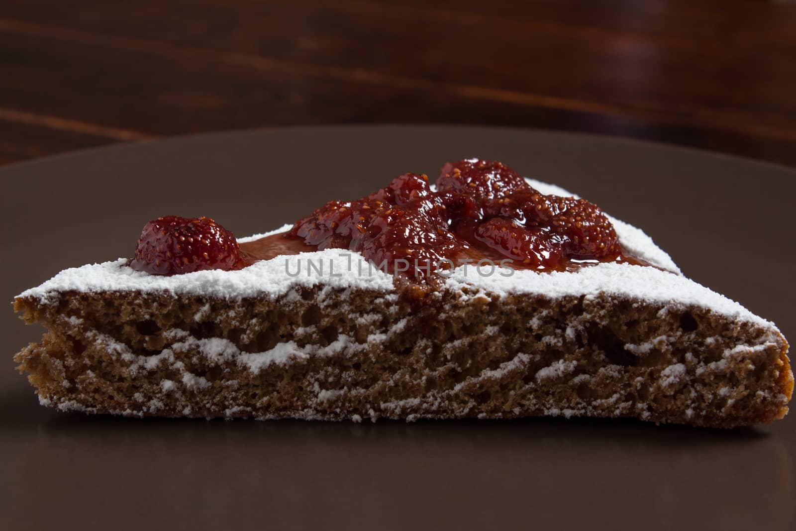 A piece of cake with strawberry jam and sugar. Dessert, food, sweet, baking. Biscuit, brownie, tiramisu, cheesecake. Cook at home, homemade, closeup, Bakery products.
