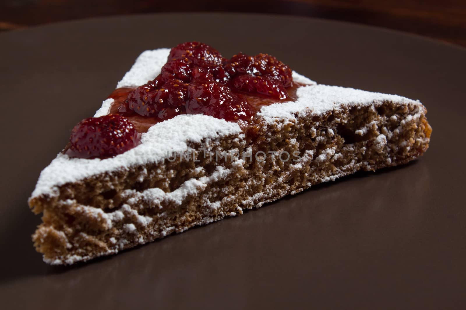A piece of cake with strawberry jam and sugar. Dessert, food, sweet, baking. Biscuit, brownie, tiramisu, cheesecake. Cook at home, homemade, closeup, Bakery products.
