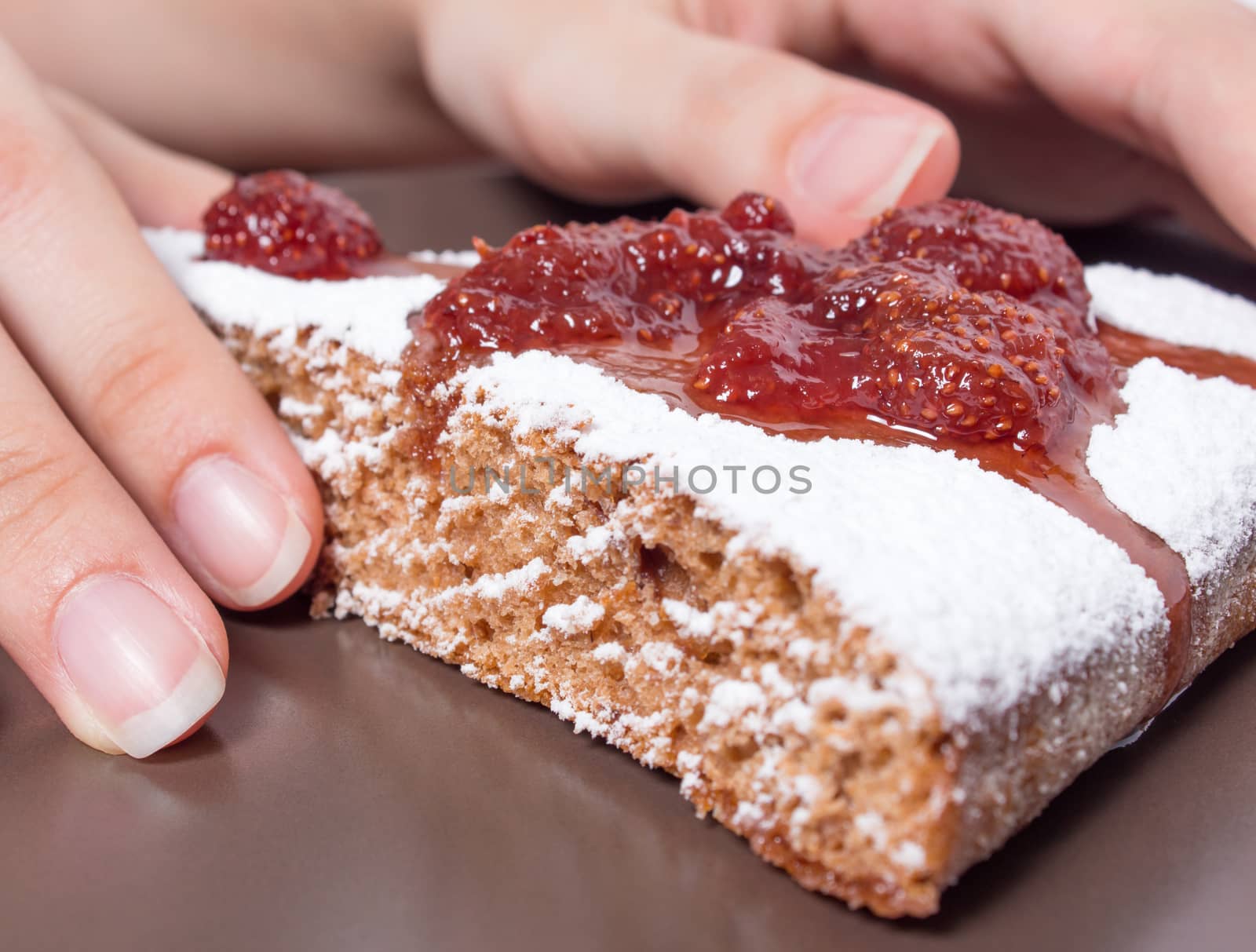 Hands  with a piece of cake with strawberry jam and sugar. Dessert, food, sweet, baking. Biscuit, brownie, tiramisu, cheesecake. Cook at home, homemade, closeup, Bakery products.