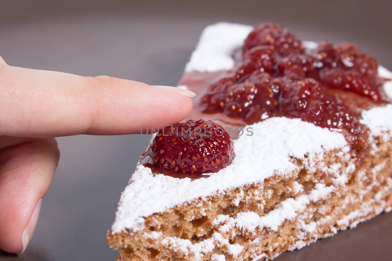 Hand holding a piece of cake with strawberry jam and sugar. Dessert, food, sweet, baking. Biscuit, brownie, tiramisu, cheesecake. Cook at home, homemade, closeup, Bakery products.