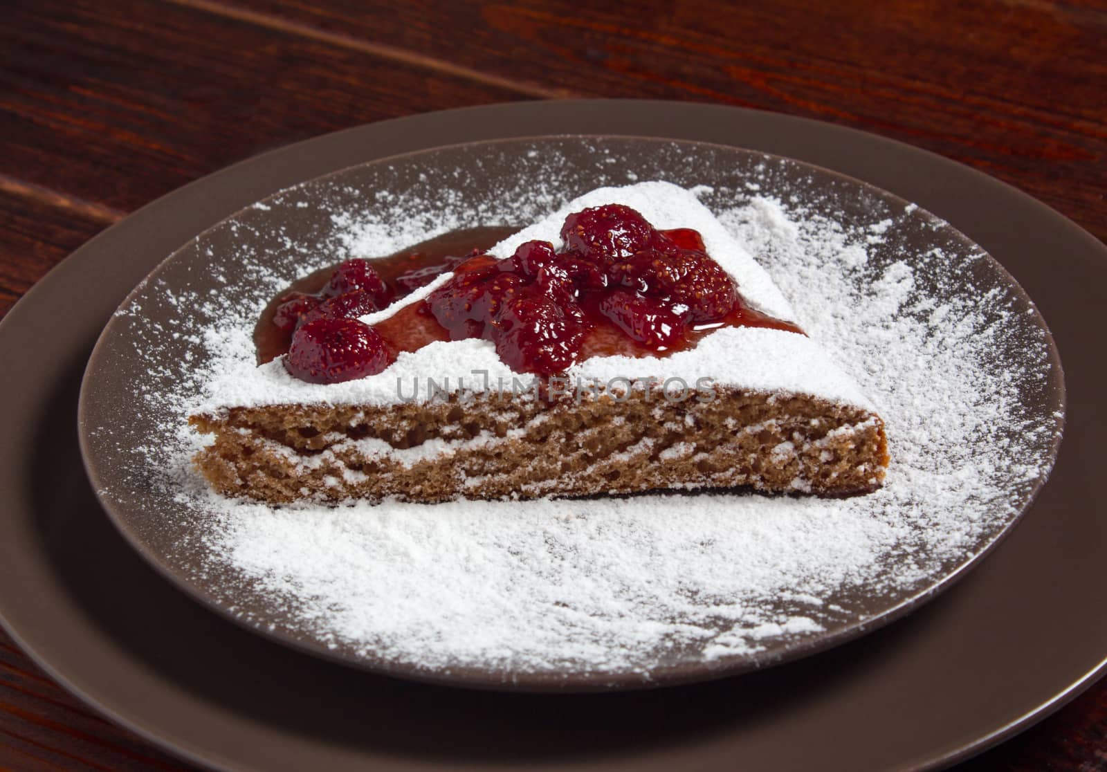A piece of cake with strawberry jam and sugar. Dessert, food, sweet, baking. Biscuit, brownie, tiramisu, cheesecake. Cook at home, homemade, closeup, Bakery products.