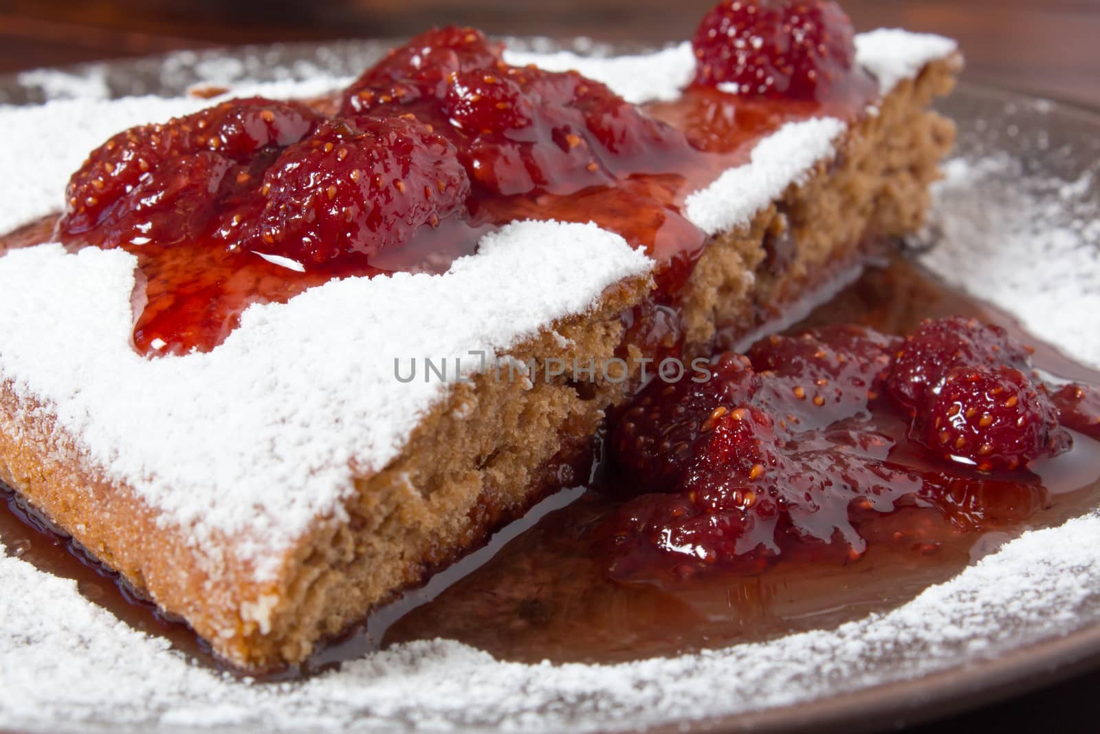 A piece of cake with strawberry jam and sugar. Dessert, food, sweet, baking. Biscuit, brownie, tiramisu, cheesecake. Cook at home, homemade, closeup, Bakery products.