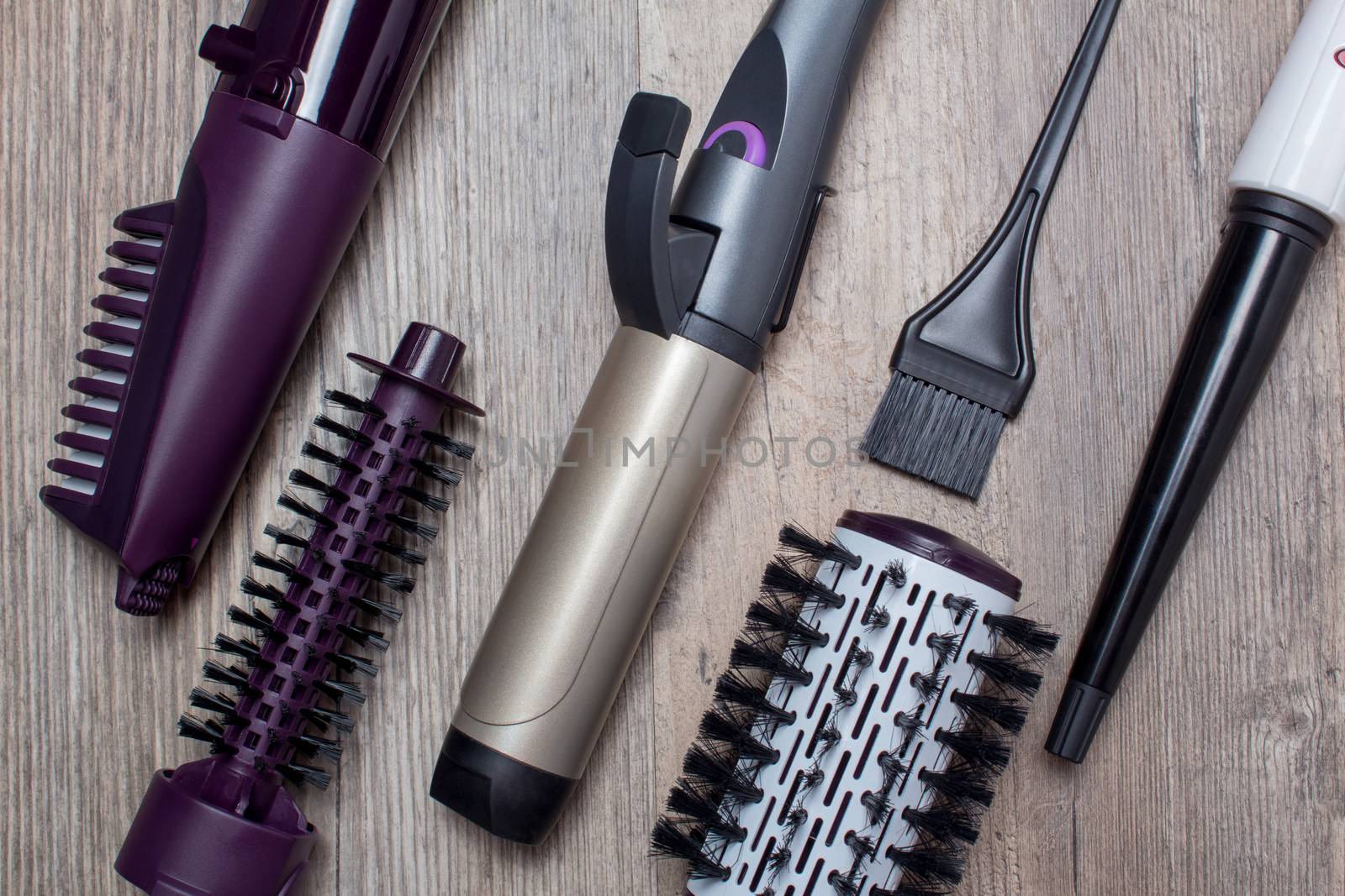 Ceramic Curling iron, hair brush on a wooden background. Hot styling, boar bristles, hair care. Beauty salon, styling, haircut. Beauty, fashion, style.