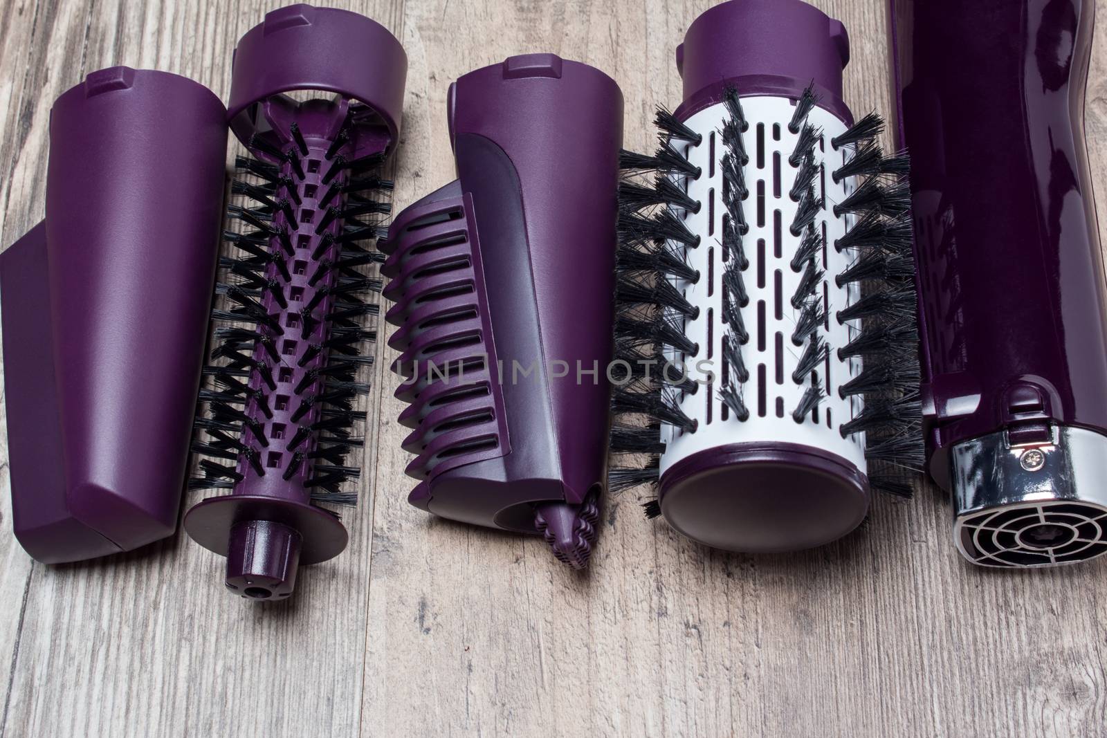 Set of hair dryer attachments on a wooden background. Curling ir by NataliSam