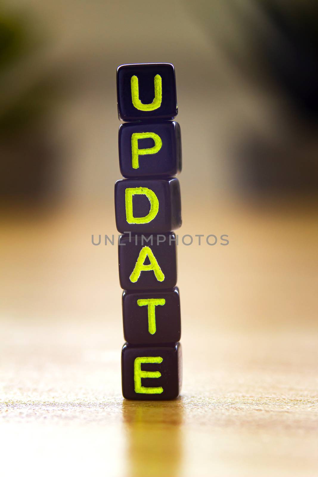 Update, vertical text in black cubes on a wooden table