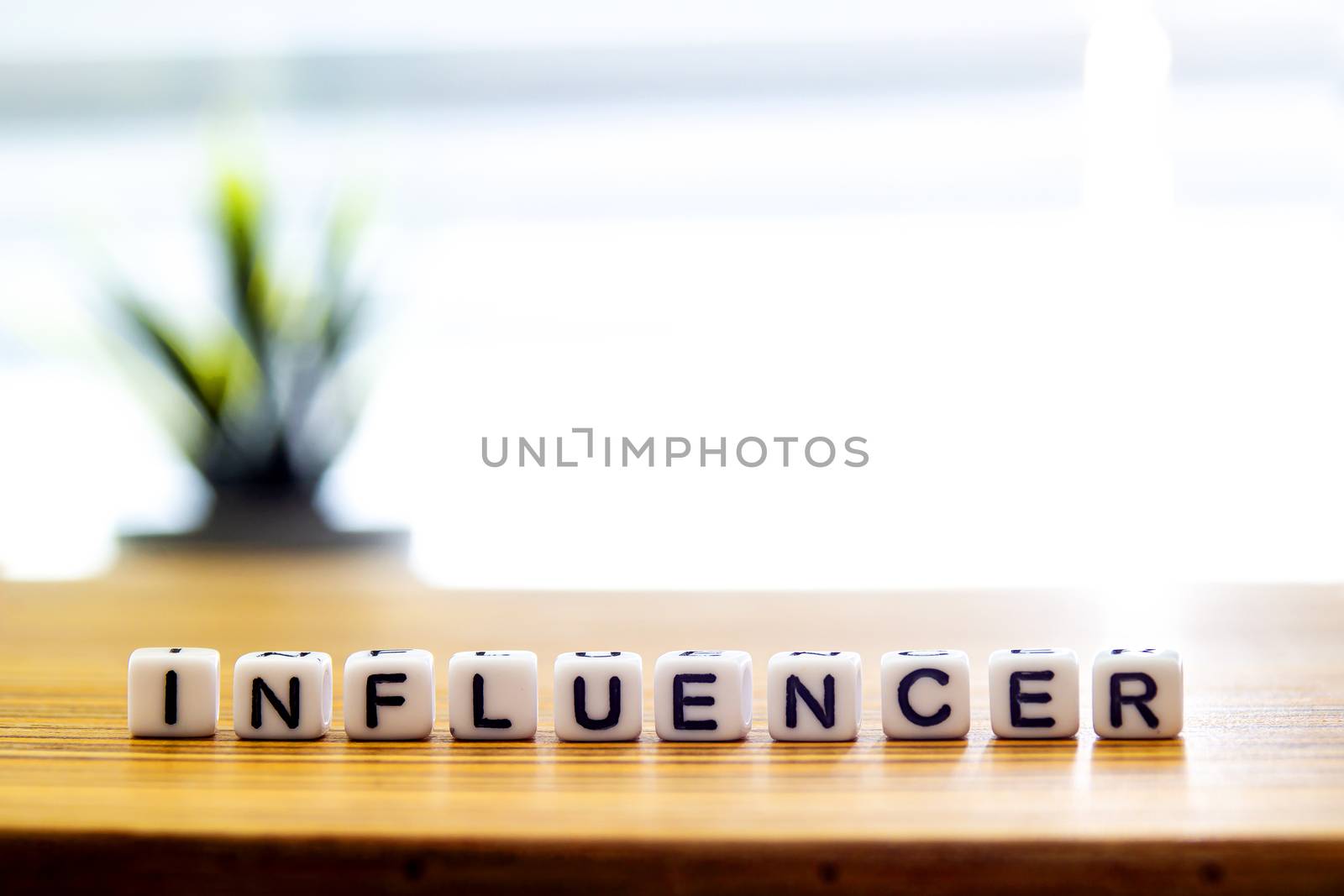 Influencer message text on white blocks on a wooden table