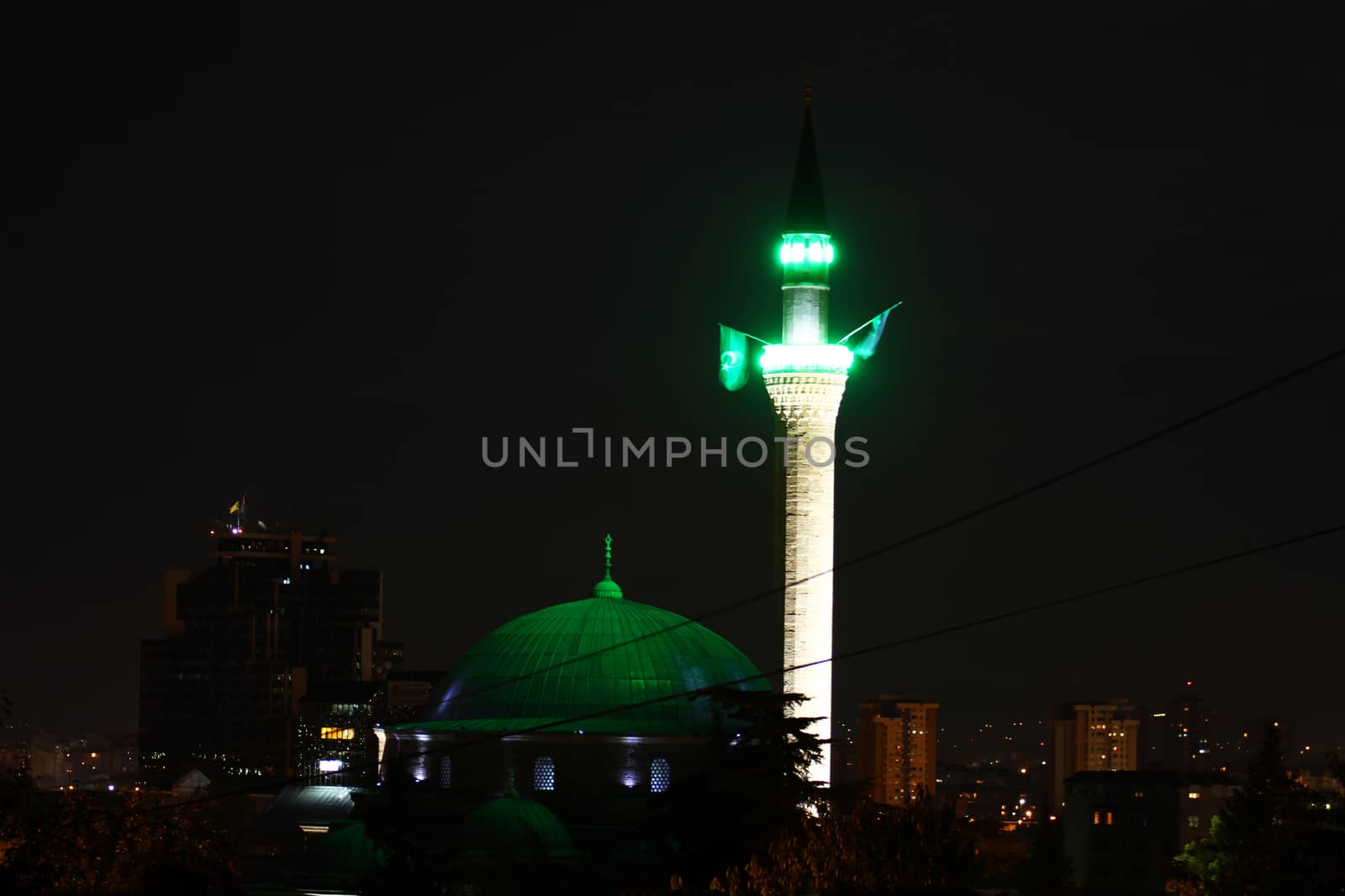 mosque at night with green light and flag