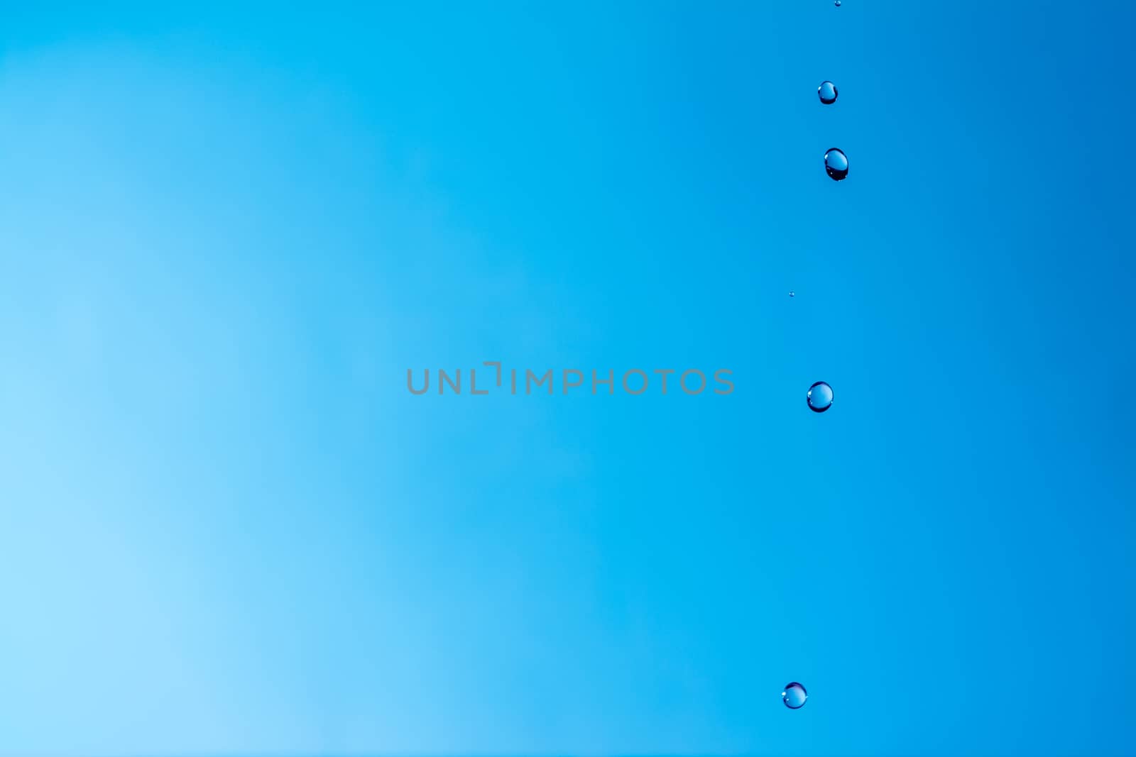 Water splash close-up. Drop of water. Blue water drop. Falling blue water surface with splash and air bubbles