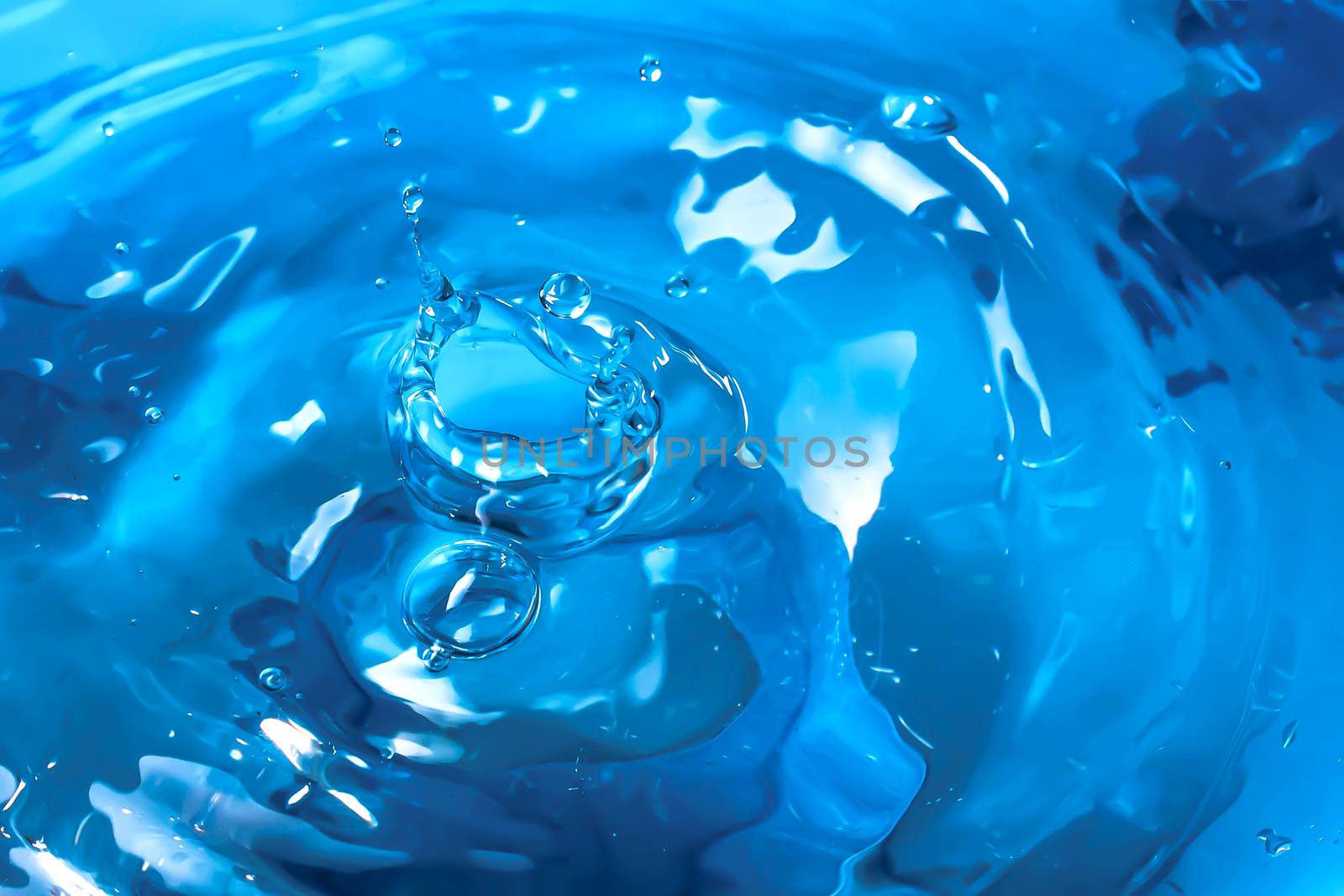 Water splash close-up. Drop of water. Blue water drop. Falling blue water surface with splash and air bubbles