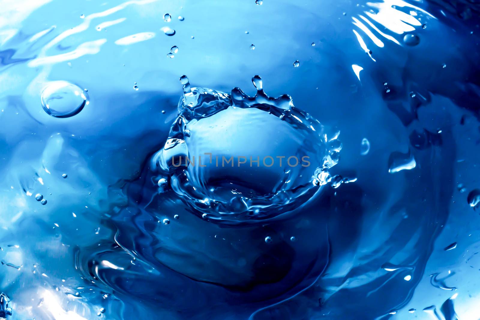 Water splash close-up. Drop of water. Blue water drop. Falling blue water surface with splash and air bubbles