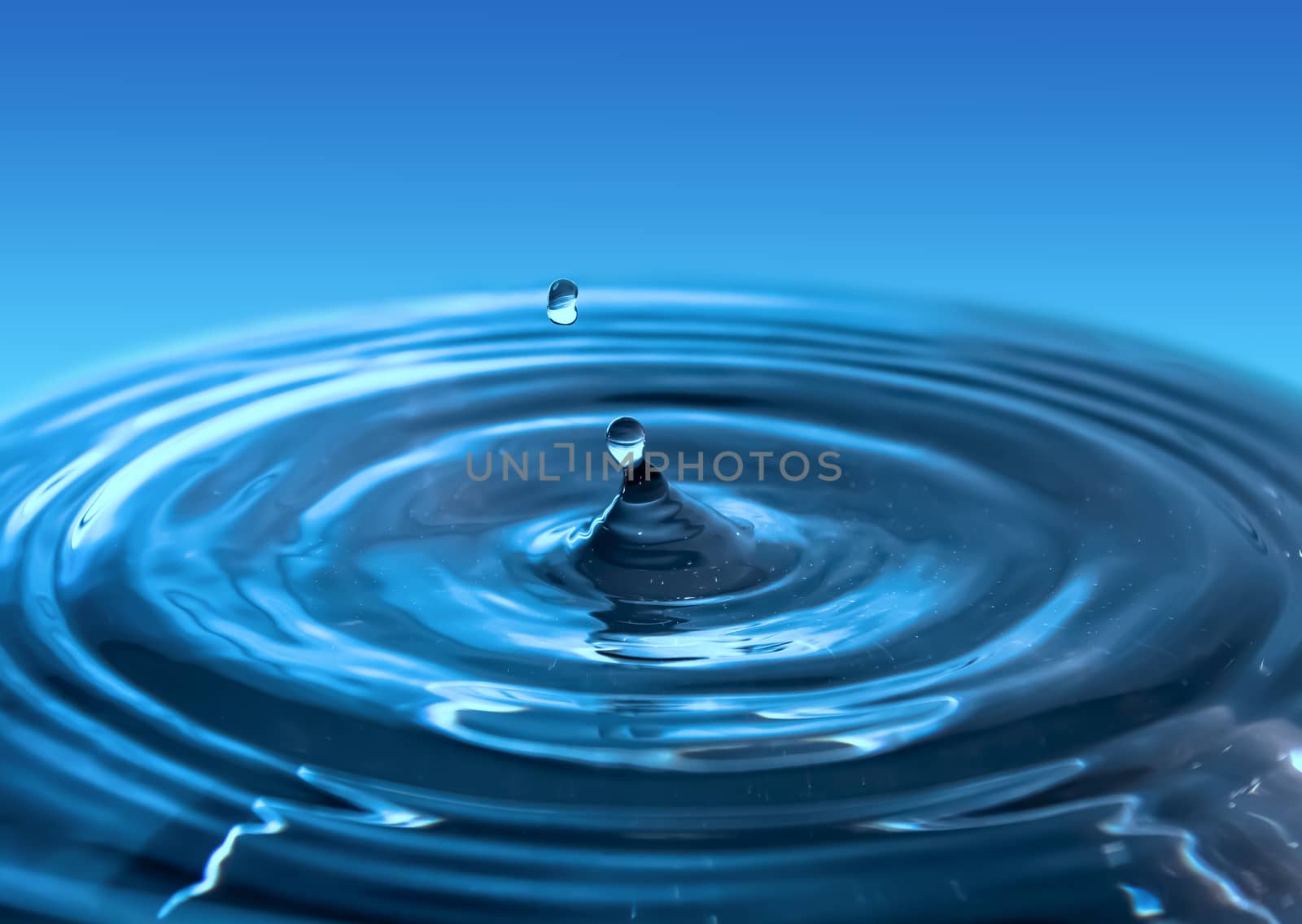 Water splash close-up. Drop of water. Blue water drop. Falling blue water surface with splash and air bubbles