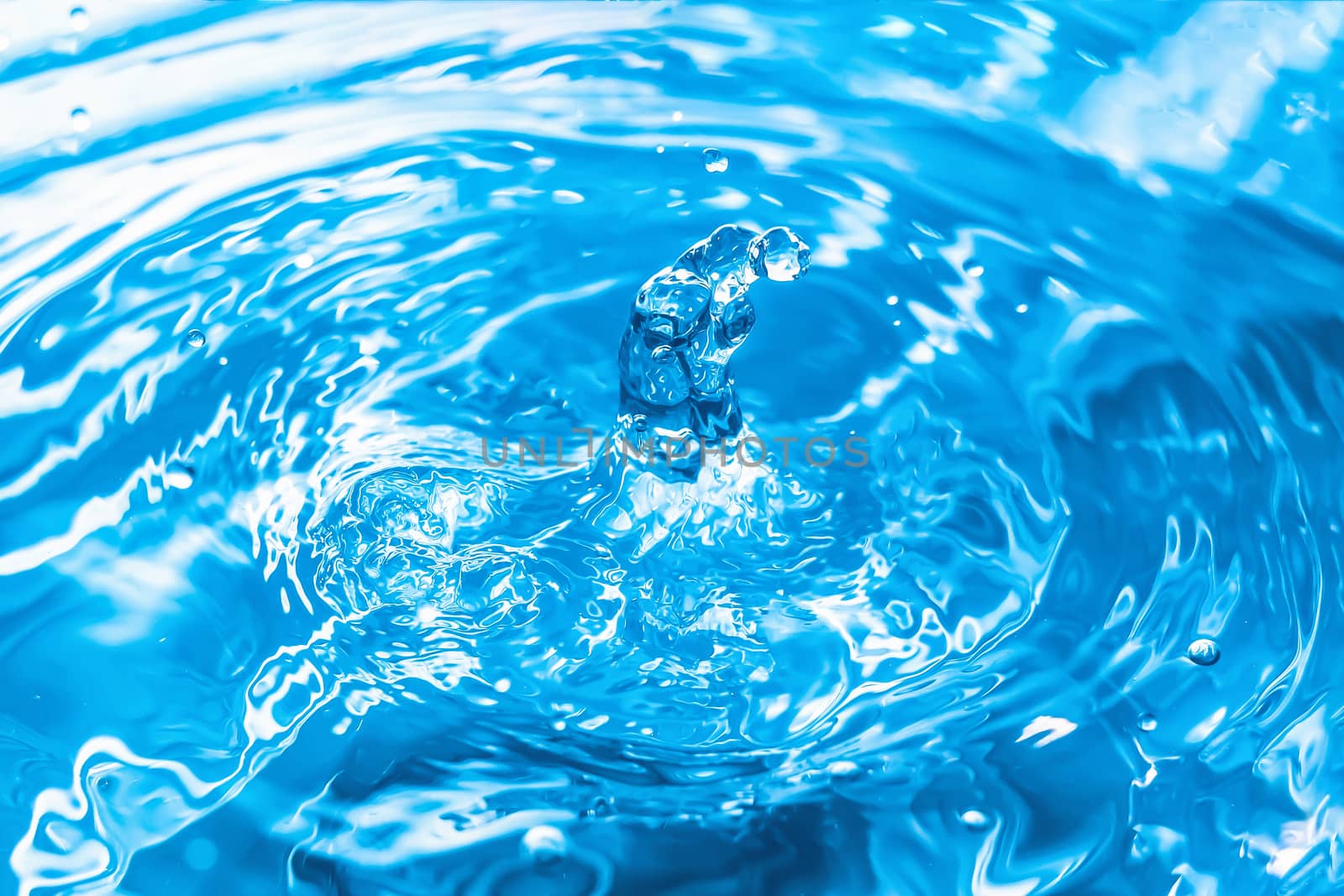 Water splash close-up. Drop of water. Blue water drop. Falling blue water surface with splash and air bubbles