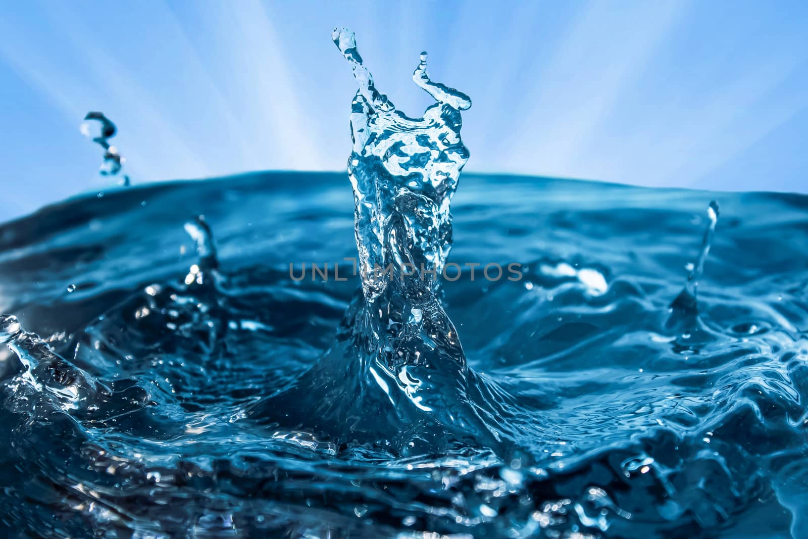 Water splash close-up. Drop of water. Blue water drop. Falling blue water surface with splash and air bubbles