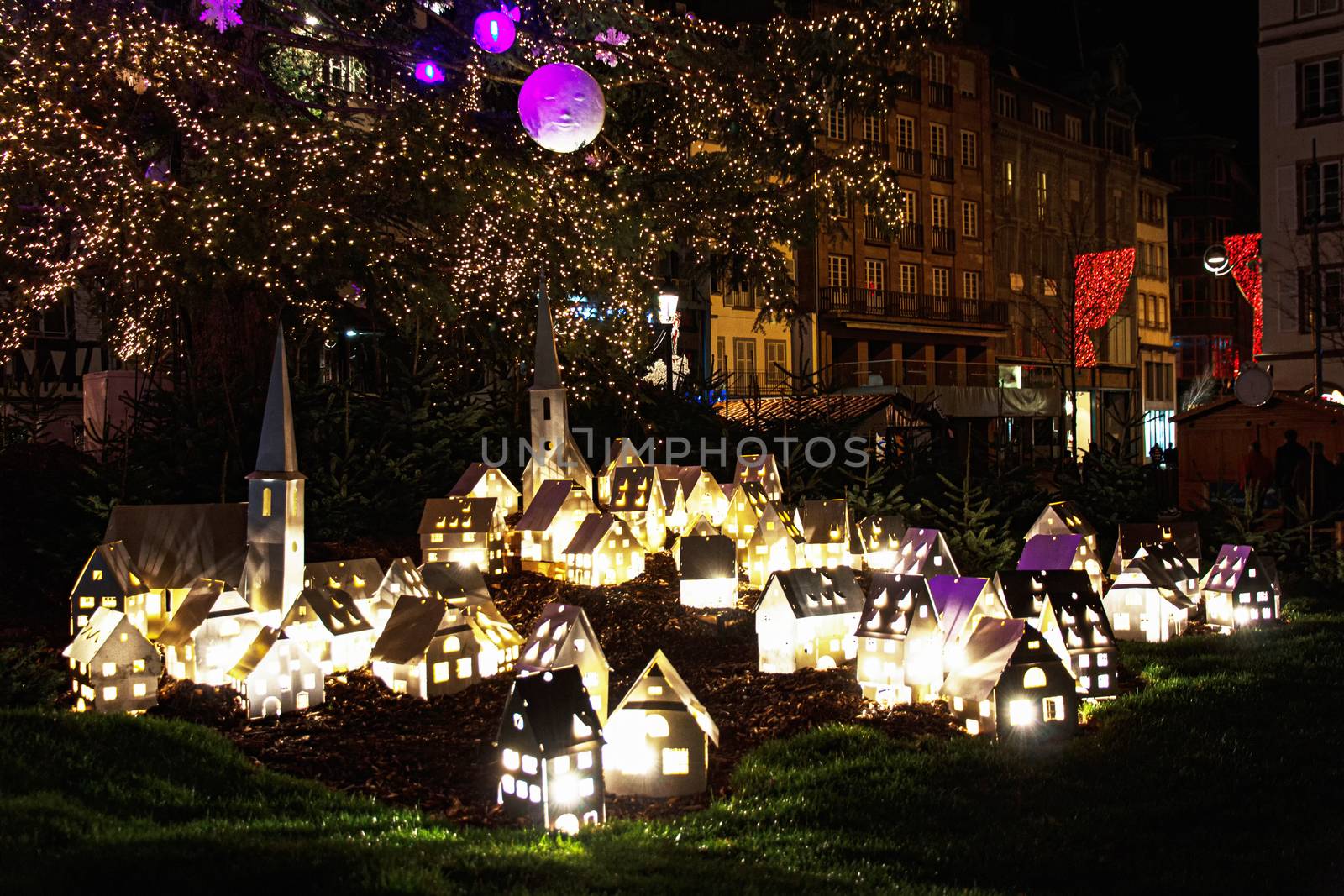 Illuminated of an Alsacian architectural village display in the Strasbourg Christmas market at night , on Klebar central city place, France
