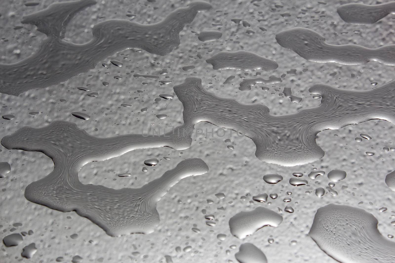 Abstract blotches of water on the surface in black and white.