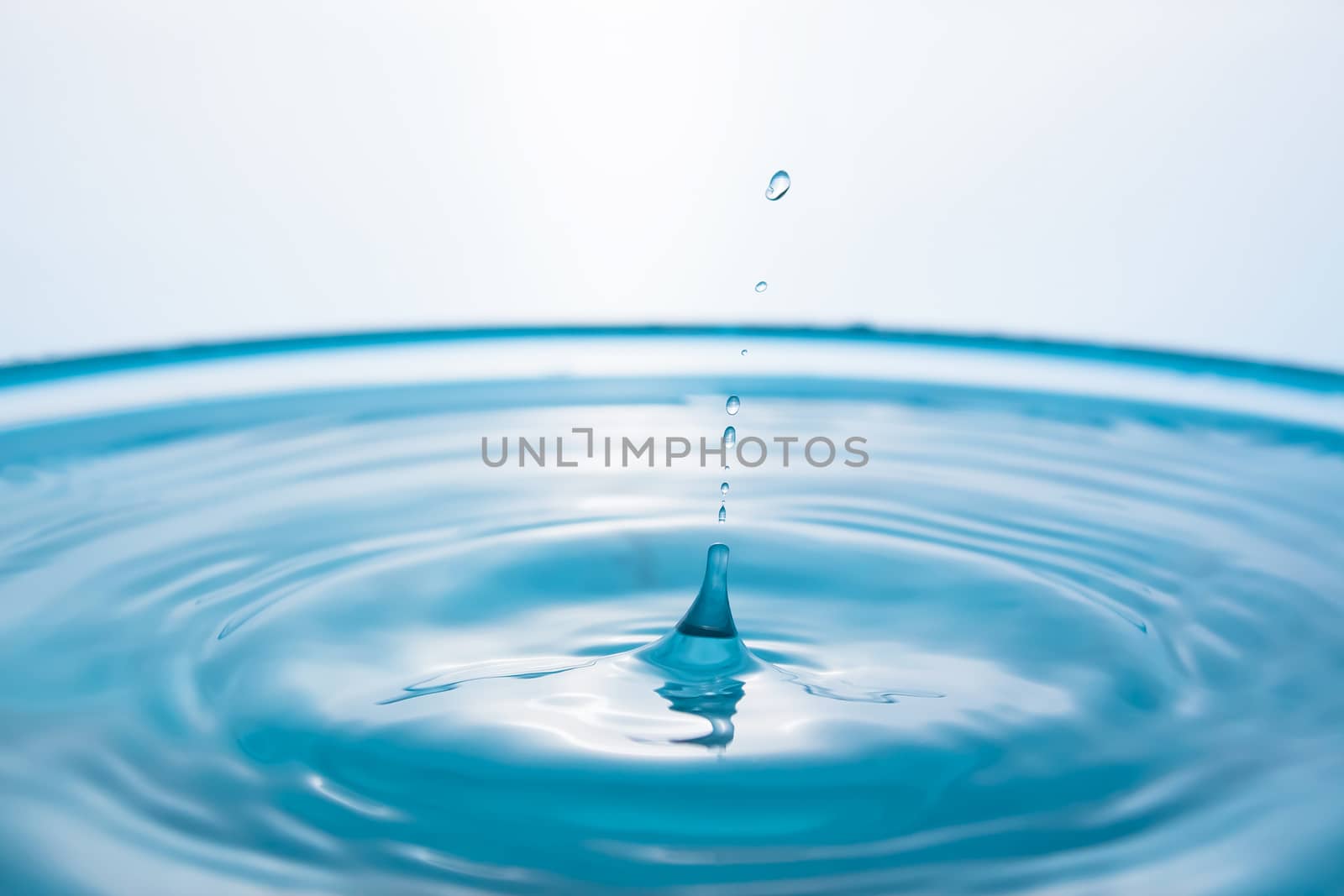 Water splash close-up. Drop of water. Blue water drop. Falling blue water surface with splash and air bubbles