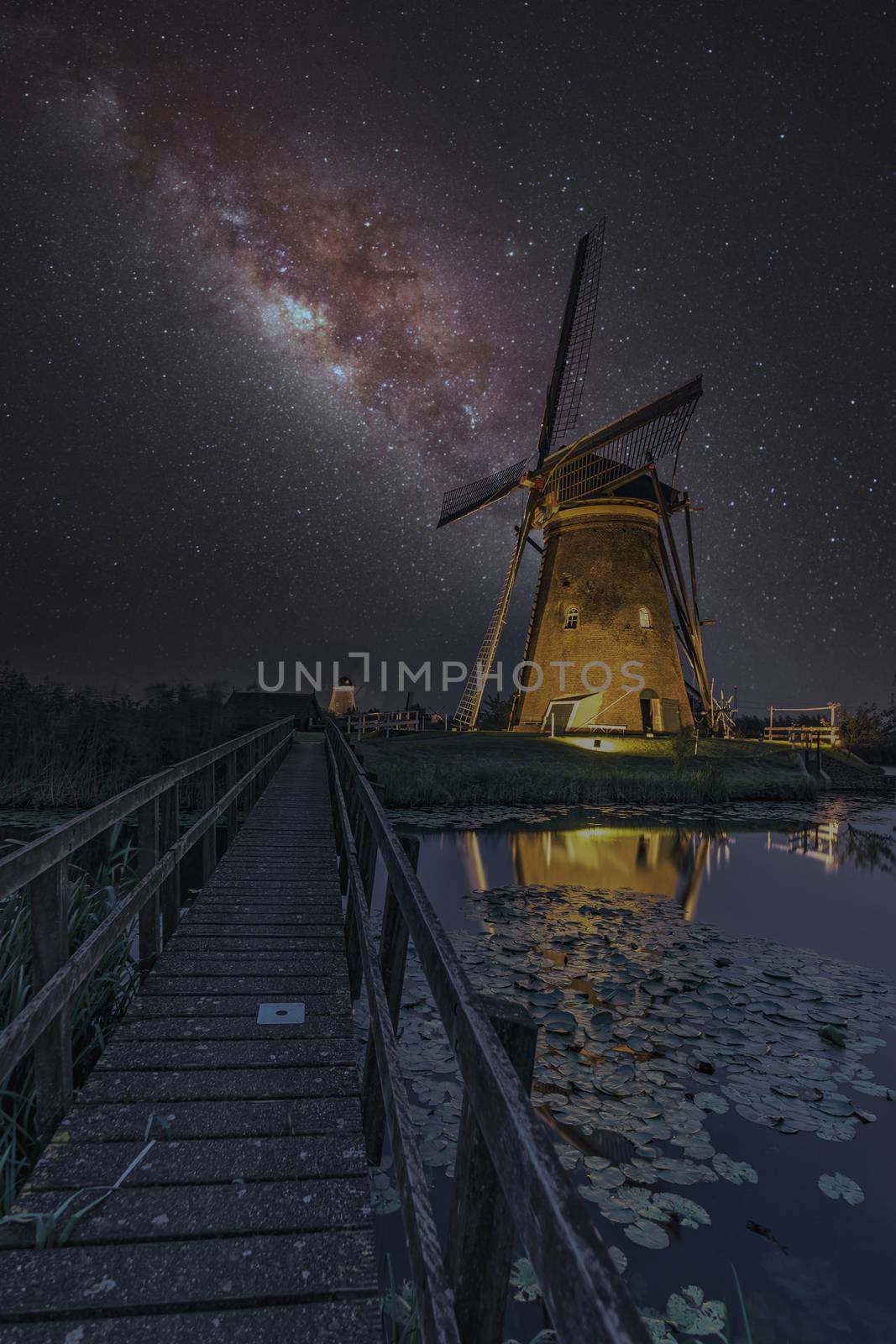 Milky way on the windmill servicing its duty under a warm cloudless and warm weather at Kinderdijk, Netherlands by ankorlight