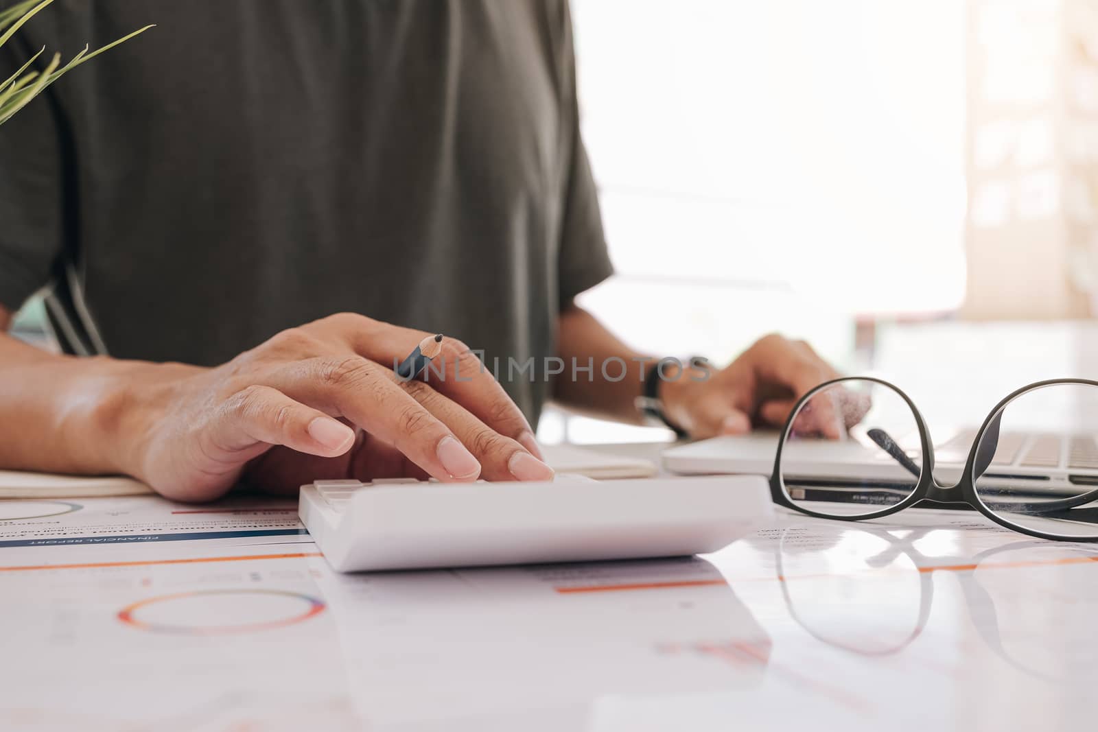 Accountant working on calculator to calculate financial report, accountancy document and computer at office, Business Financial Concept

