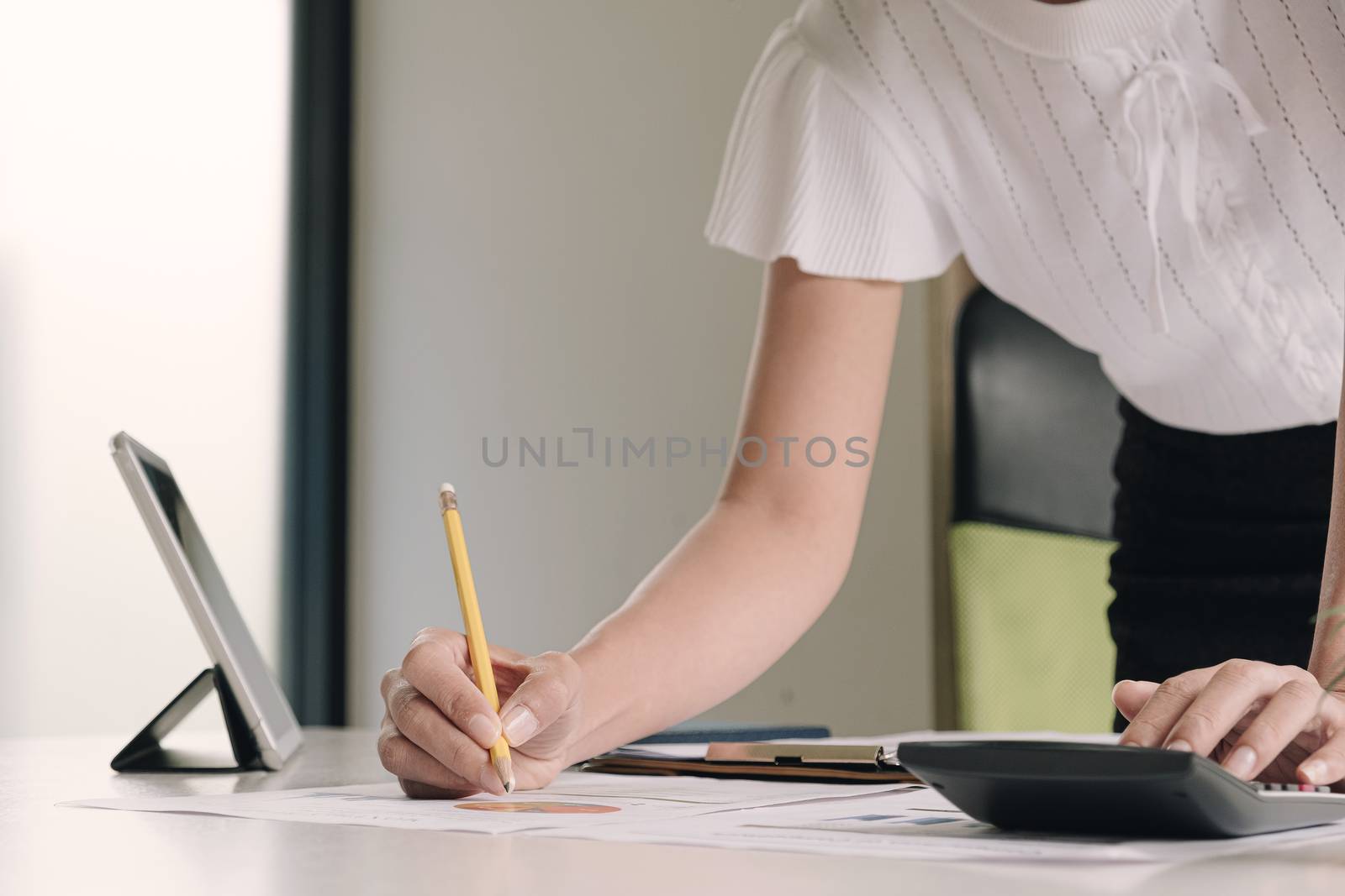 Close up Businesswoman using calculator and laptop for do math finance on wooden desk in office and business working background, tax, accounting, statistics and analytic research concept
