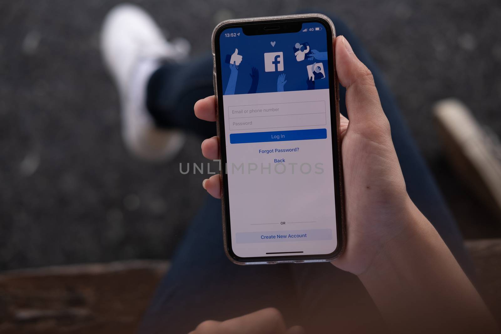 CHIANG MAI, THAILAND - JUL 16, 2019: Facebook social media app logo on log-in, sign-up registration page on mobile app screen on iPhone X (10) in person's hand working on e-commerce shopping business
