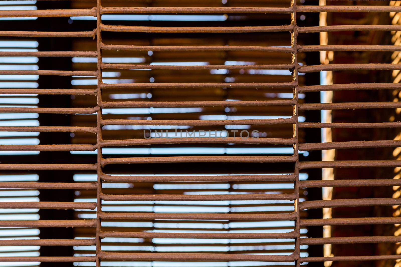 Rusted welded iron fence closeup with selective focus. View on ventilation underground structure.