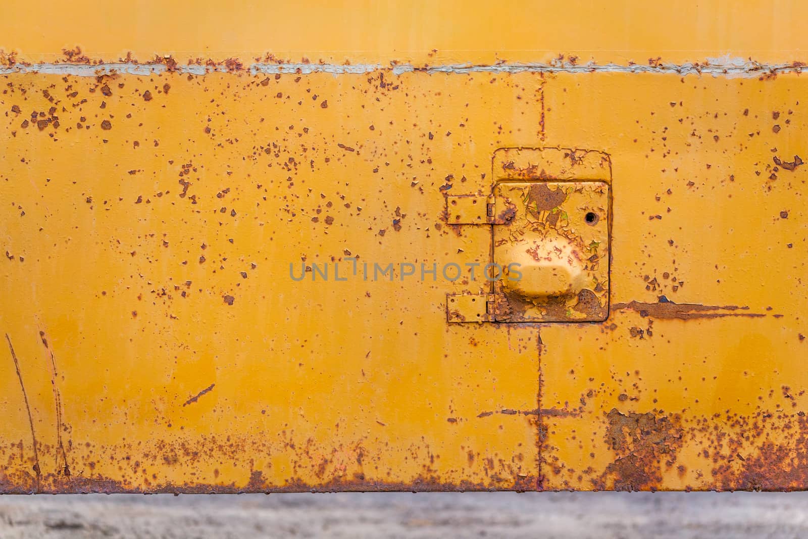 rusted yellow bus board with small hatch closeup with selective focus