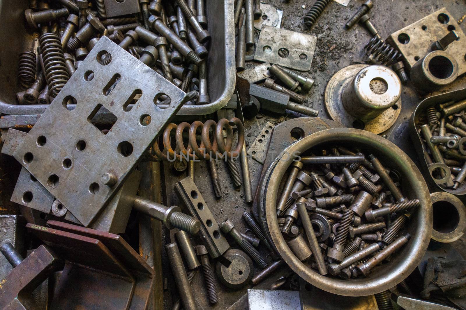 Rusted springs and bolts junk background. View from above on top of working messy table.