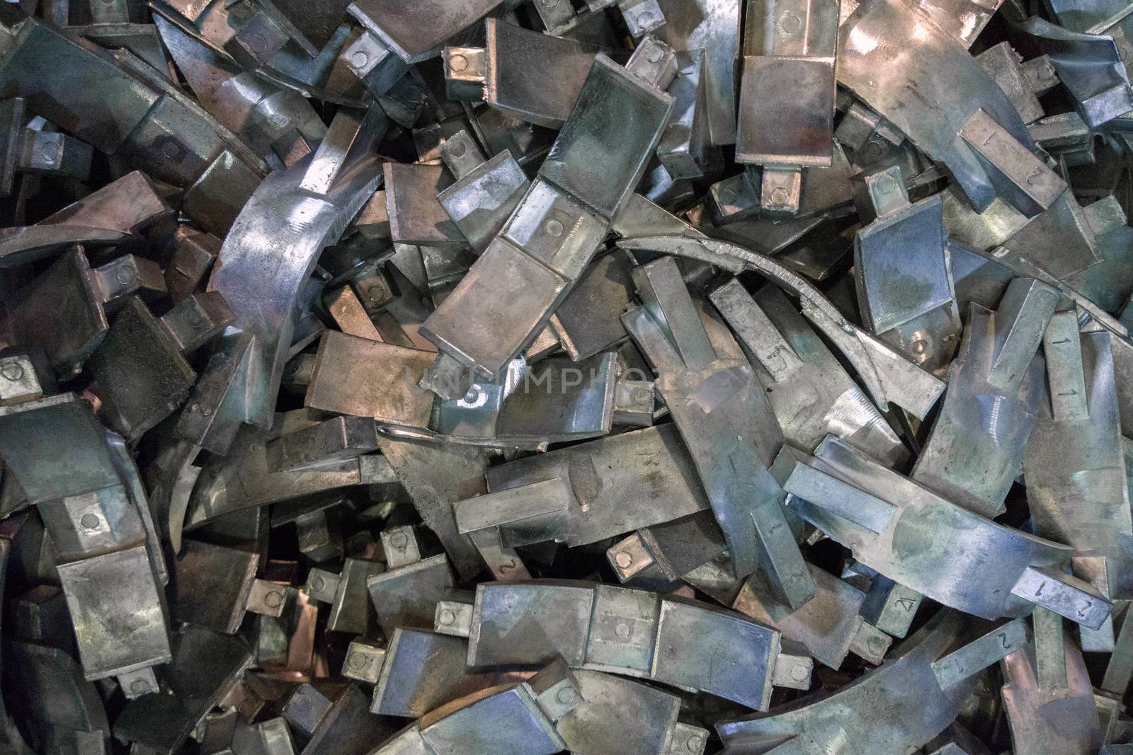 Many complex aluminium castings with burrs flat background with selective focus. View from above