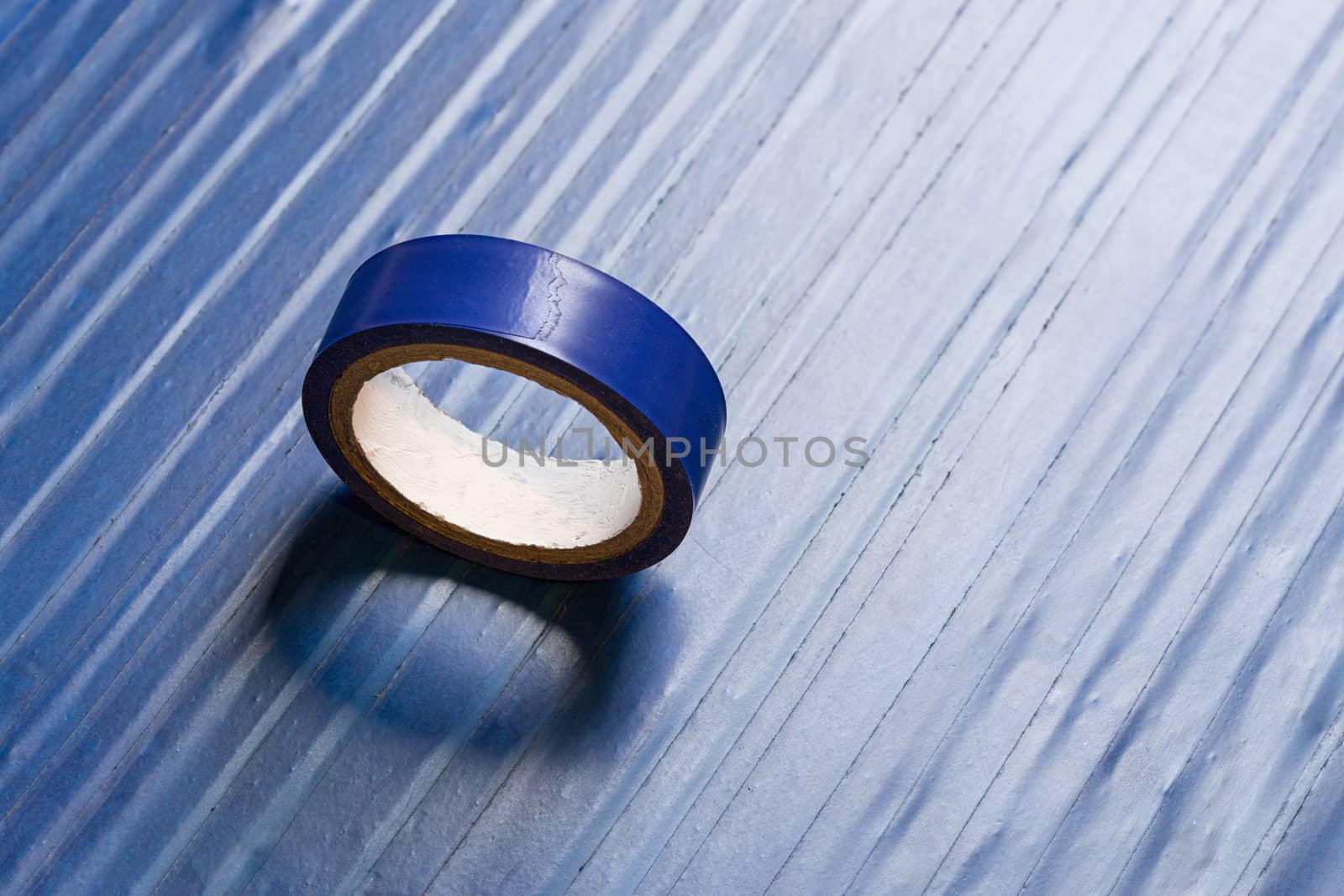 one roll of old blue pvc duct tape on surface covered by same tape